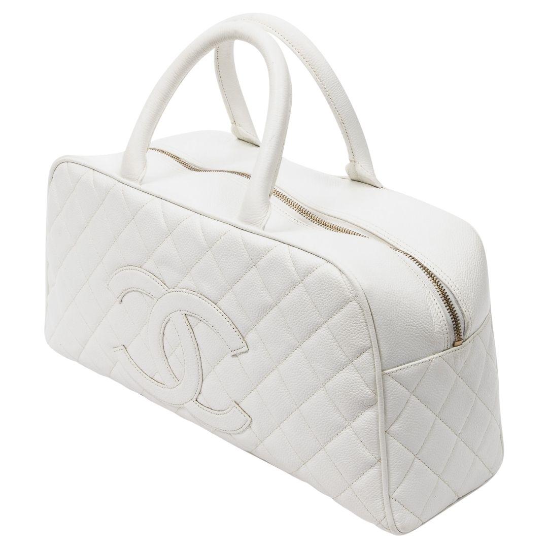 A sophisticated white caviar leather top handle bag with gold hardware and zipper closure. The grosgrain interior includes one pocket for organization.

SPECIFICS
Length: 14.6
Width: 4.7
Height: 7.9
Strap drop: 4
Authenticity code: 8163726