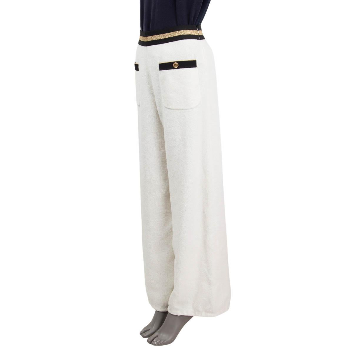 100% authentic Chanel 2019 La Pausa terrycloth wide leg pants in white cotton (83%) and polyamide (17%), with an elastic waistband in black and gold polyester (70%), latex (25%) and polyamide (5%). Feature two 'CC' buttoned patch pockets on the