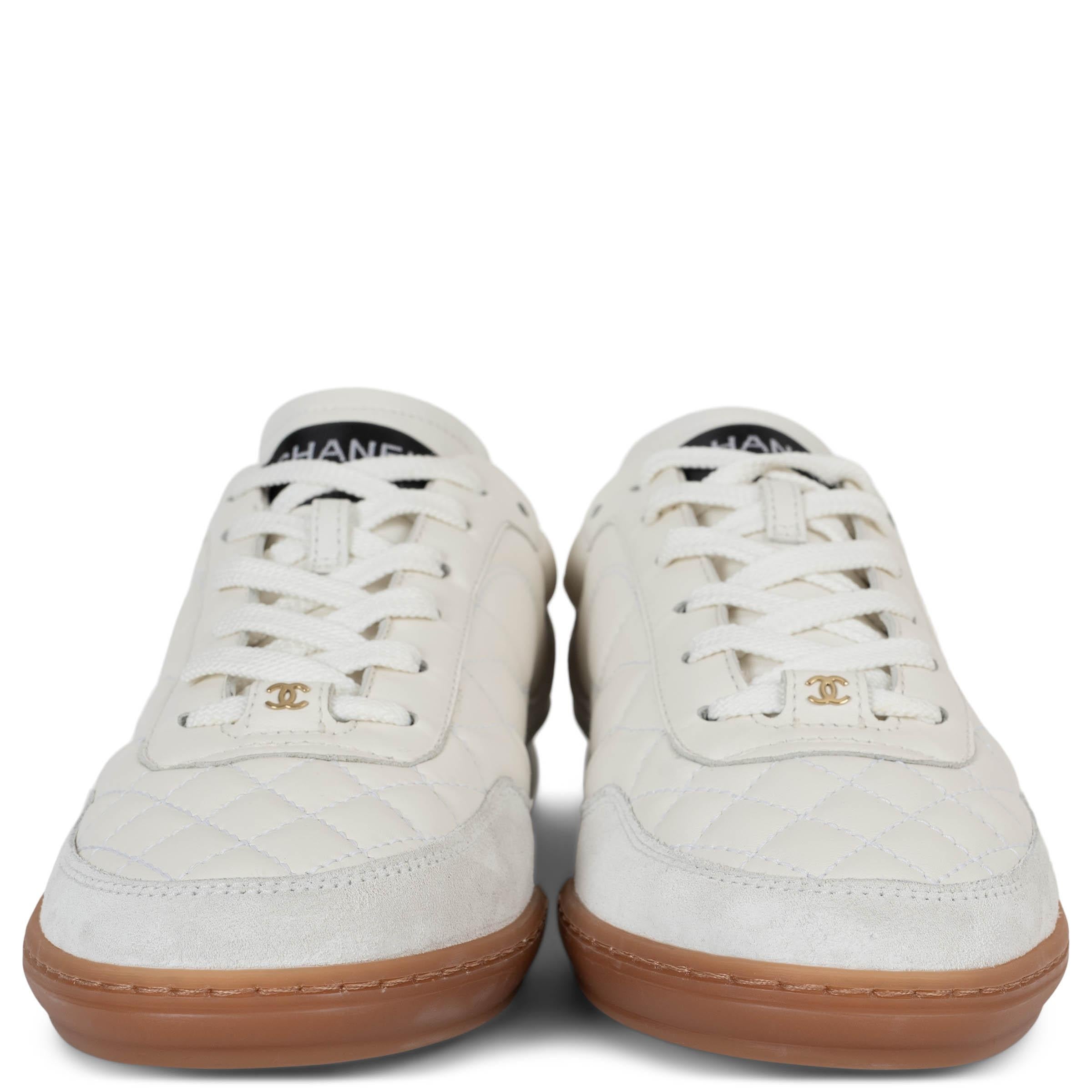 This 100% authentic Chanel low-top sneakers in cream quilted leather redefine casual elegance with signature detailing. Accented with light grey suede and white leather trims, they feature rounded toes for a timeless silhouette. A discreet CC logo