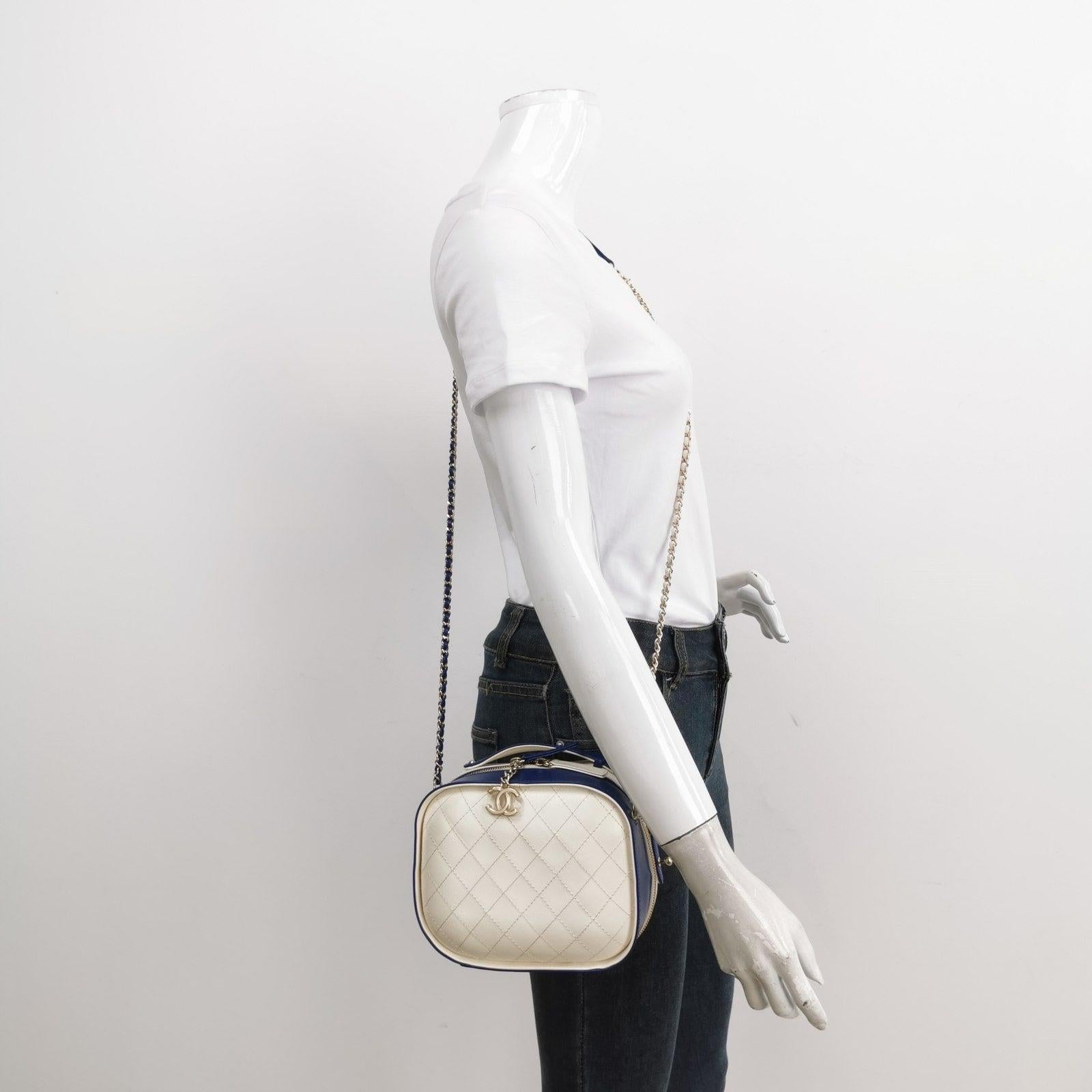 Chanel White and Blue Small Crumpled Calfskin Vanity Case Crossbody Bag
  These are professional photos of the actual bag.
  
  This vanity case showcases a crumpled calfskin exterior, a crossbody chain strap, a zip-top closure, and inner slip