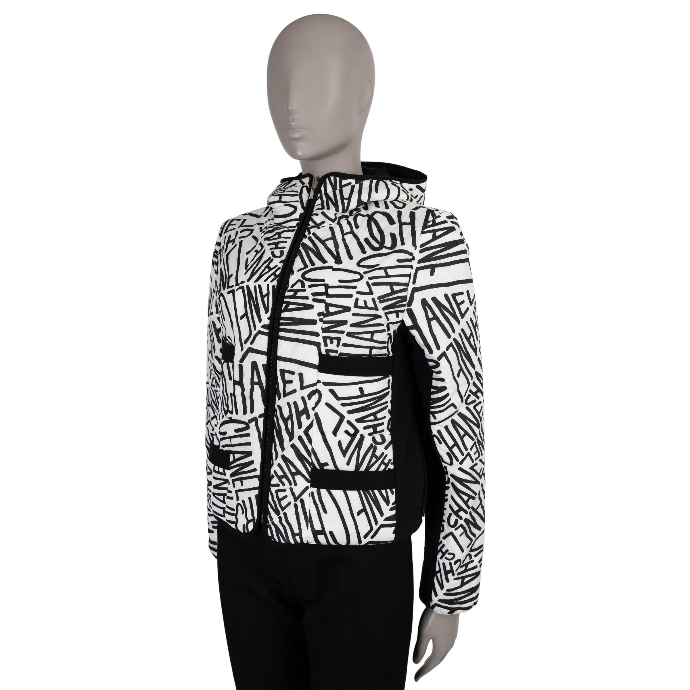This 100% authentic Chanel reversible ski jacket in polyester (100%) offers both style and versatility on the slopes. One side features bold black logo writing on white, while the reverse is solid black for a sleek, understated look. Designed with a