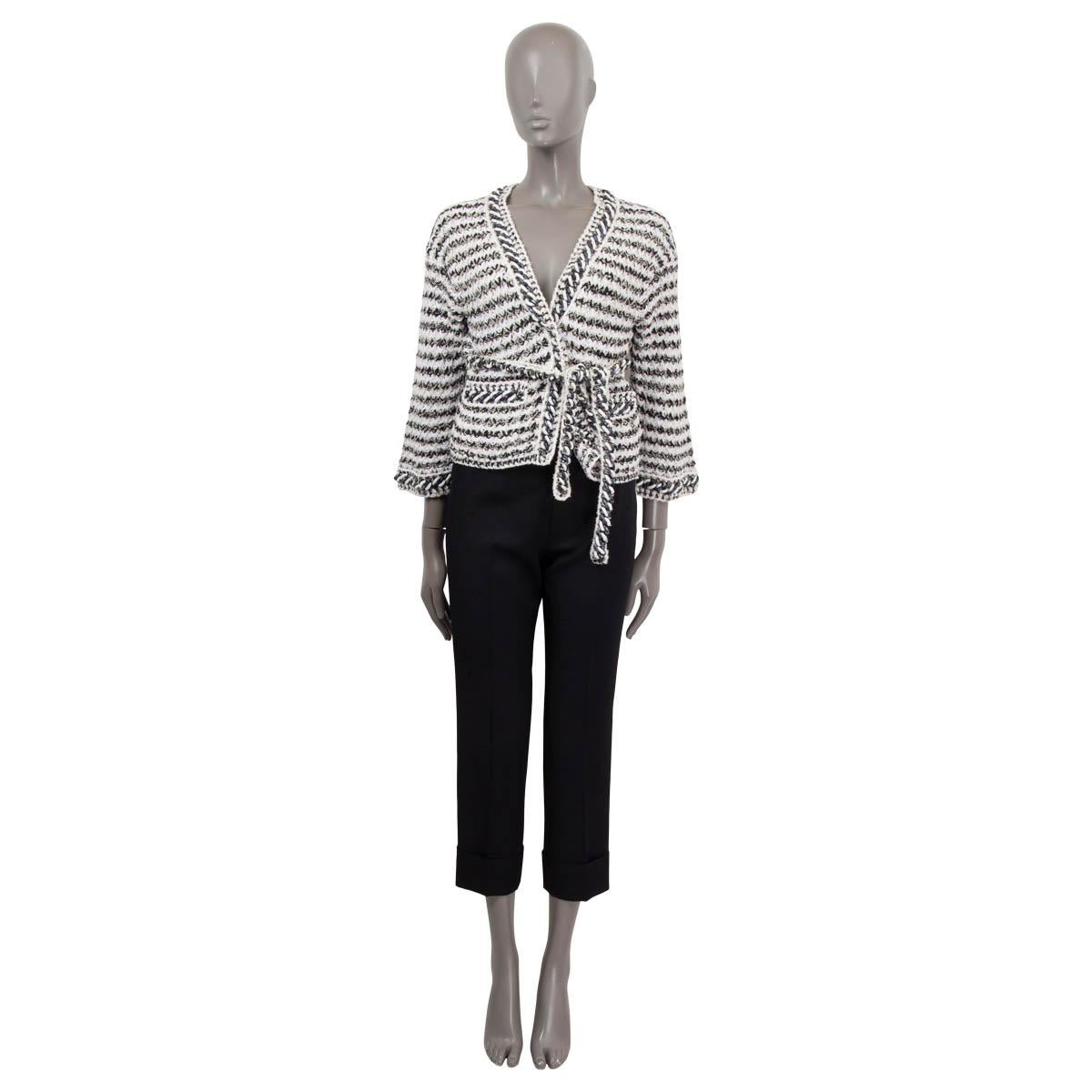 100% authentic Chanel striped knit jacket in black, white and ivory cotton (77%) and polyamide (23%). Features grey and white chain trim in acetate and has two classic chain embellished patch-pockets at front. Closes with a self-tie belt and is
