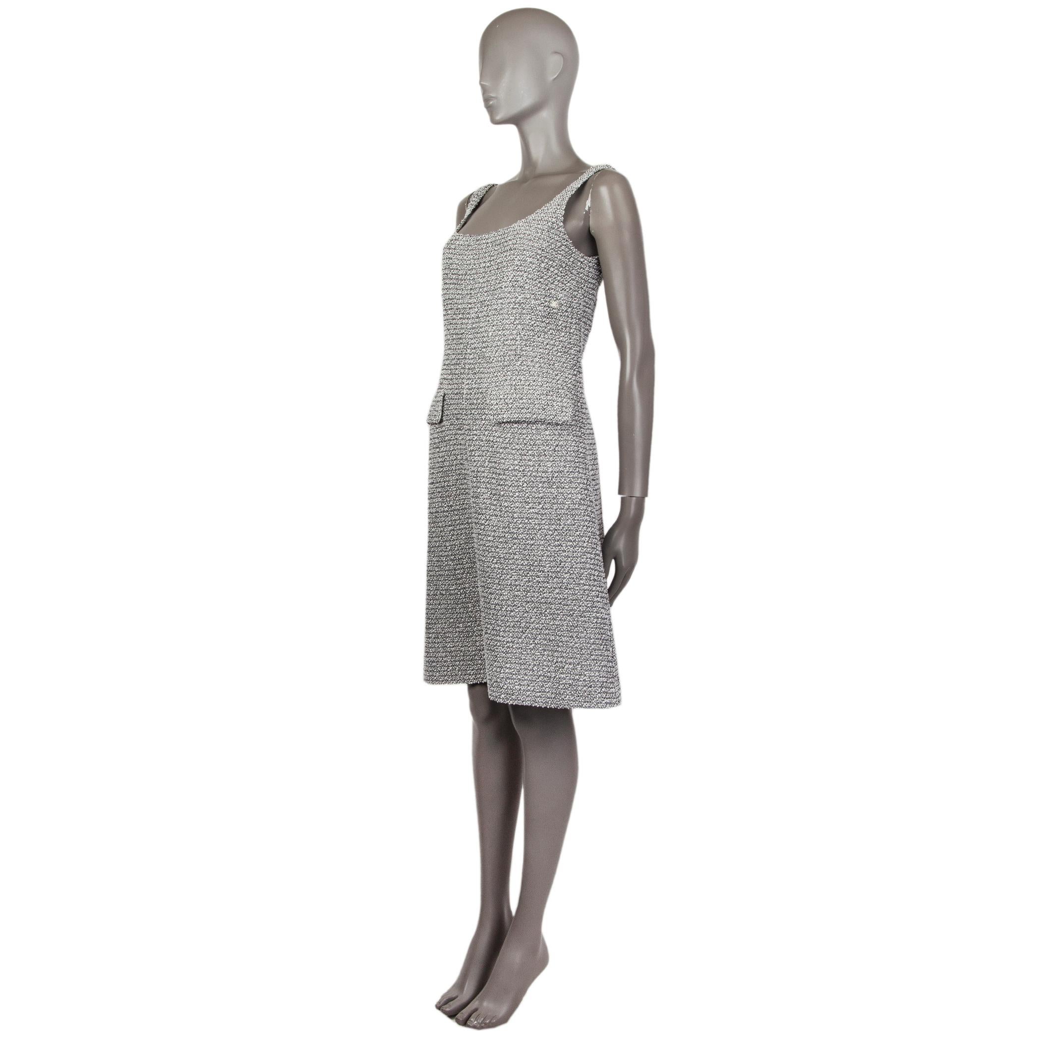 Chanel boucle shift dress in white and black cotton (90%) and nylon (10%). With two flap pockets on the front. Closes with hook and invisible zipper on the back. Lined in signature camelia-print off-white silk (100%). Has been worn and is in