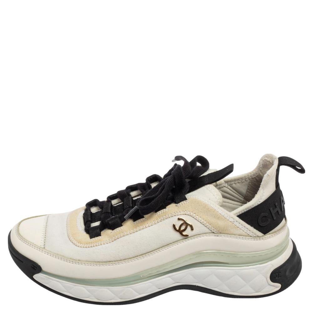 Sport a trendy look as you flaunt these sneakers from the House of Chanel. They are made from white-black fabric, leather trims, and suede into a sturdy low-top silhouette. Their vamps feature a lace-up fastening and brand detailing. Update your