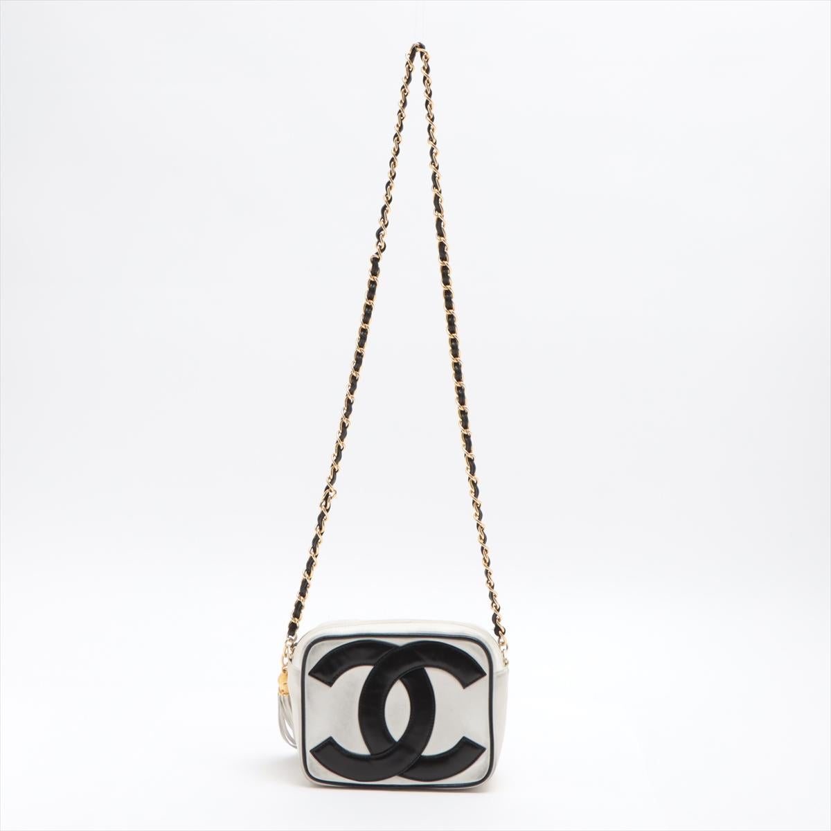 This vintage Chanel bag is crafted from white leather and adorned with the brand's black logo appliqué on both sides, featuring zip closure with tassel, single long chain woven chain-link and leather shoulder strap, white leather lining, one zip