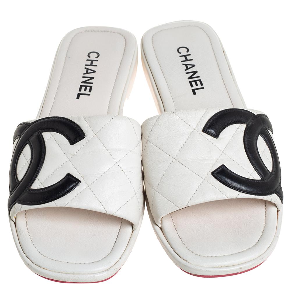 This pair of Chanel sandals will keep your look chic and summery. Made from leather, their white vamps are designed with the signature quilted stitch, coupled with interlocking black CC logos on the outer sides. They are designed with a short wedge