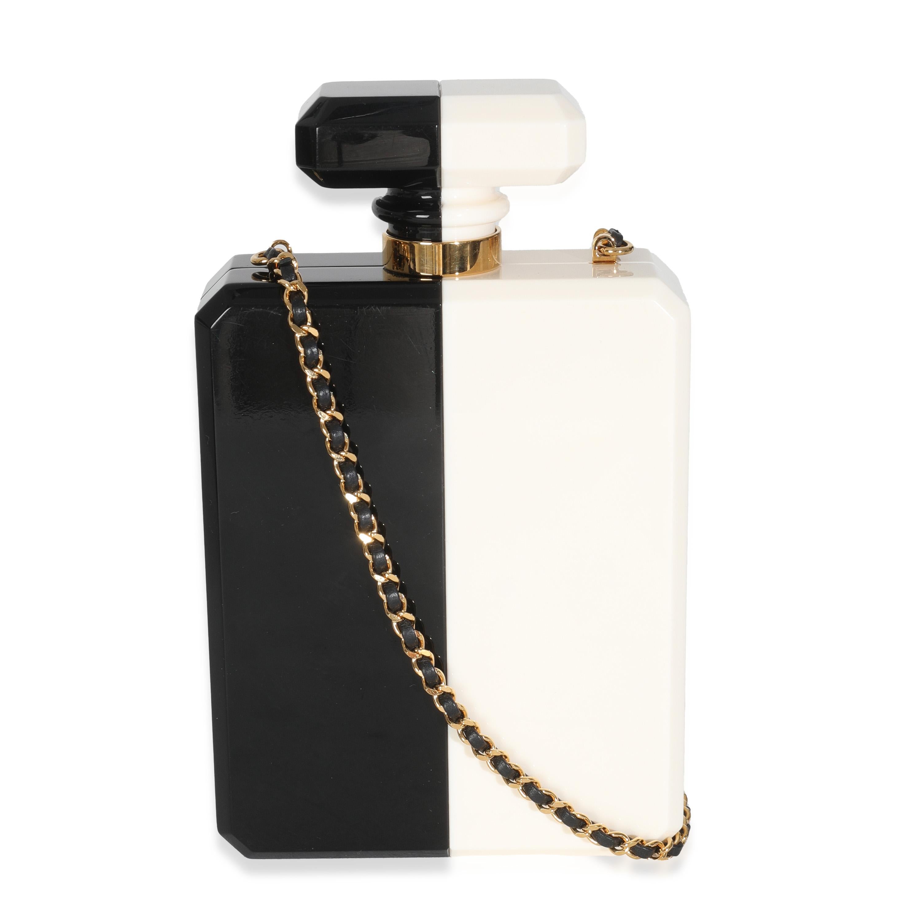 Titre du listing : Chanel Pochette pour bouteille de parfum en plexiglas blanc et noir
SKU : Z147535
Condit : Usagé 
Condition du sac à main : Excellent
Commentaires sur l'état : L'article est en excellent état et présente de légers signes d'usure. 