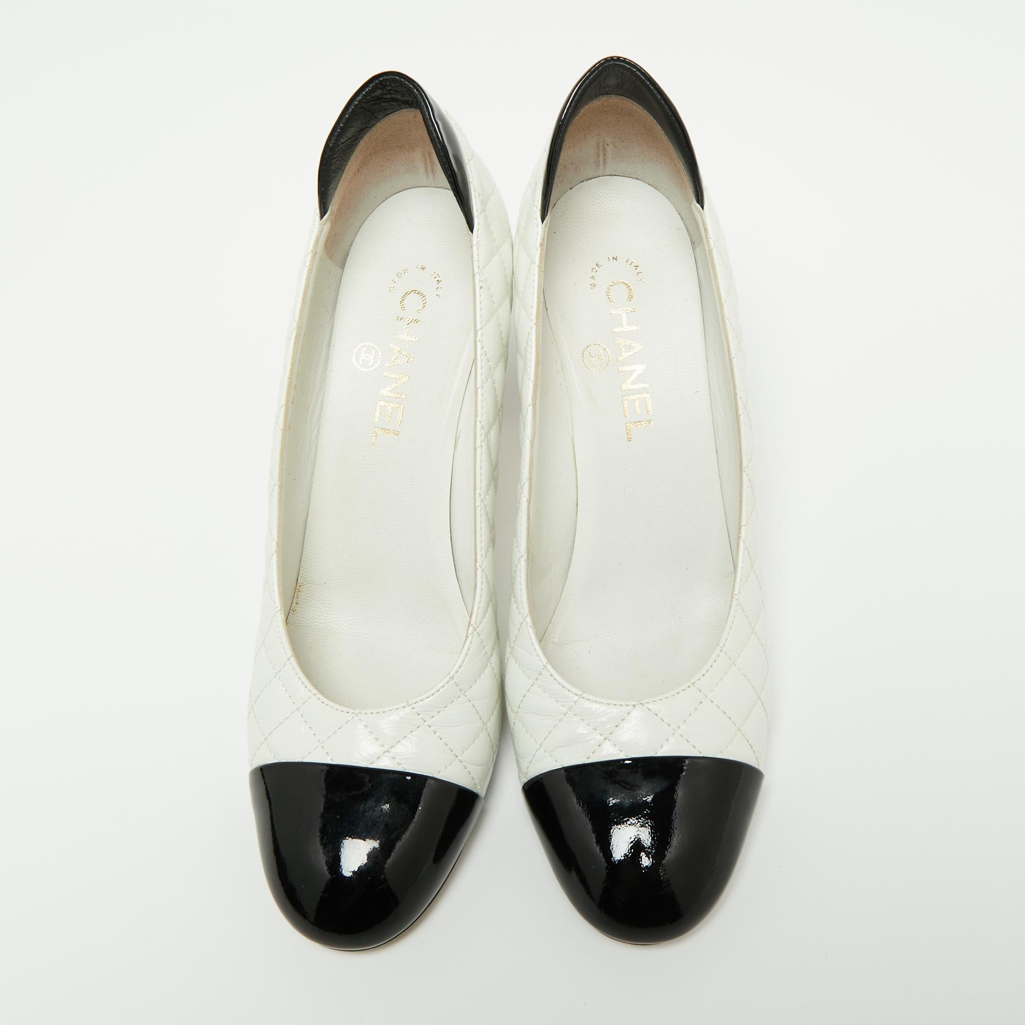 From the House of Chanel come these pumps to elevate the look of your attire. They are crafted using white-black quilted leather and patent leather. They showcase cap toes, a slip-on style, and 8.5 cm heels. They are adorned with silver-tone