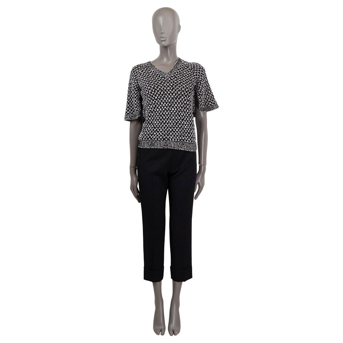 Top en maille 100% authentique de Chanel en soie noire (65%) et coton (35%) avec embellissement en cordon tissé en noir et blanc. Col en V et manches courtes en forme de cape. A été porté et est en excellent état.

2017