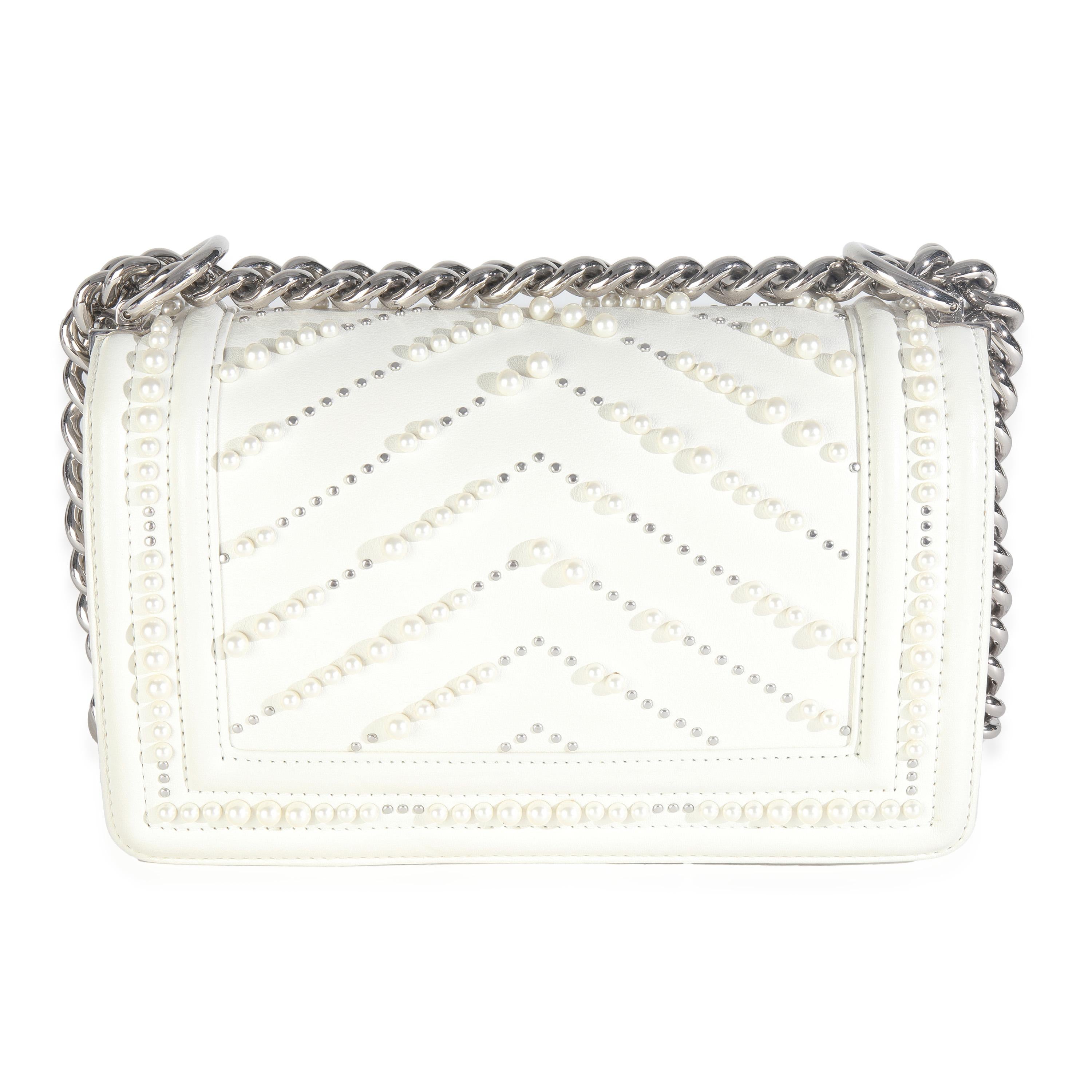Titre de la liste : Chanel - Petit sac à main en cuir de veau blanc avec perles et chevrons
SKU : 148874
MSRP : 5700.00 USD
Condit : Usagé 
Description de l'état : Classique instantané, le sac Boy de Chanel a été lancé en 2011. Le sac matelassé a