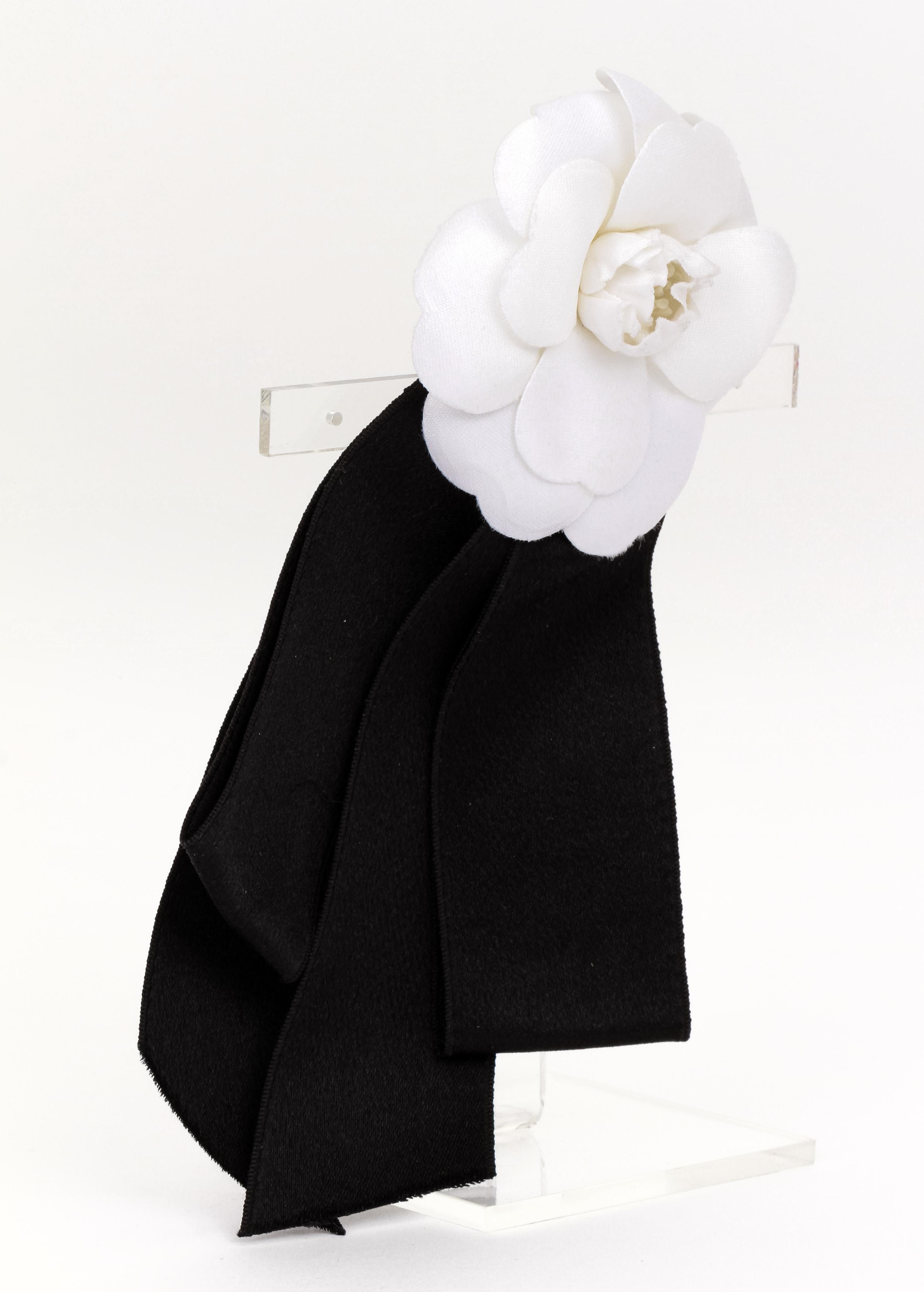Chanel large white fabric camellia brooch with black silk bow attached. Comes with velvet pouch.