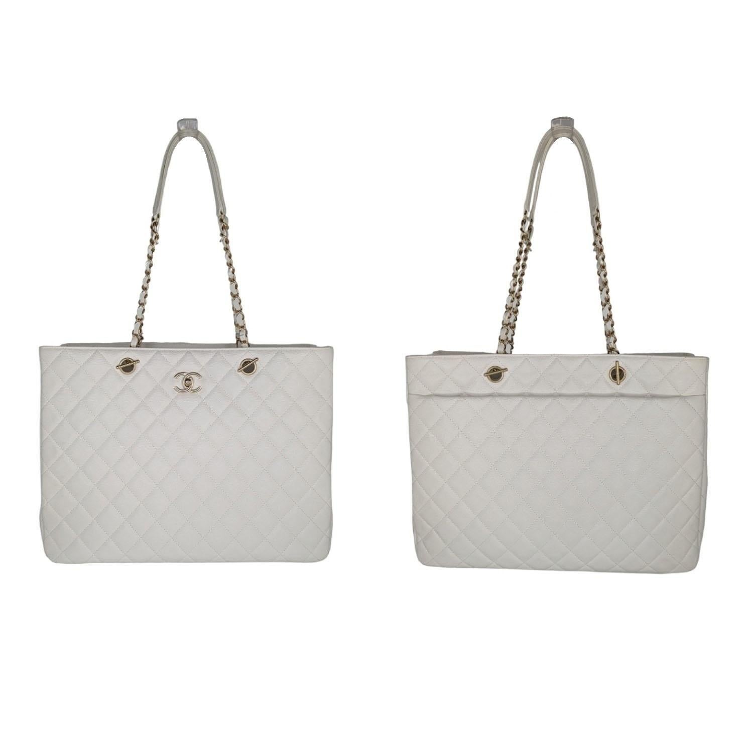 This large classic tote is crafted of diamond quilted caviar leather in white. It features polished gold chain link leather threaded shoulder straps, a polished gold Chanel CC turn lock on the front and a spacious back pocket. The top opens to a