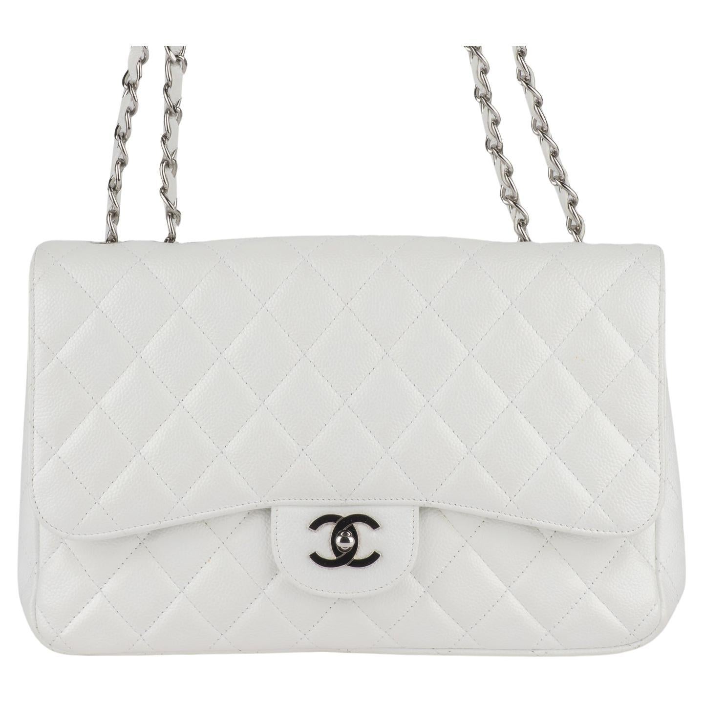 Le sac à rabat jumbo de Chanel est en cuir matelassé de diamants blancs. Une bandoulière à maillons en cuir argenté poli, une poche arrière plaquée et un cadenas CC classique argenté assorti. Cela permet d'ouvrir le sac et de révéler une poche