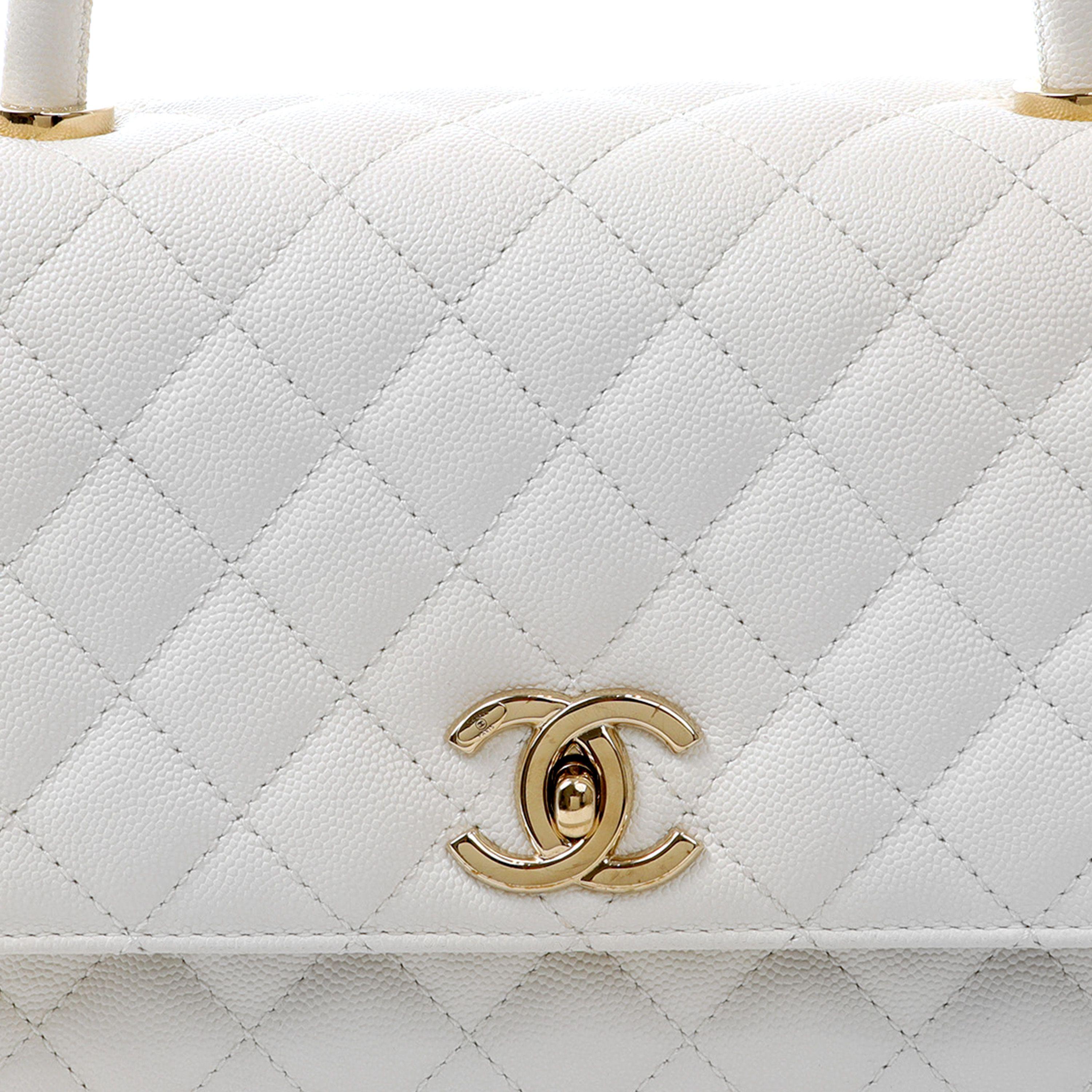 This authentic Chanel White Caviar Large Lady Handle Bag is in pristine condition.  Elegant and sophisticated, the Lady Handle is an exquisite departure from the Classic Flap silhouette. 

Textured snowy white caviar leather is quilted in signature