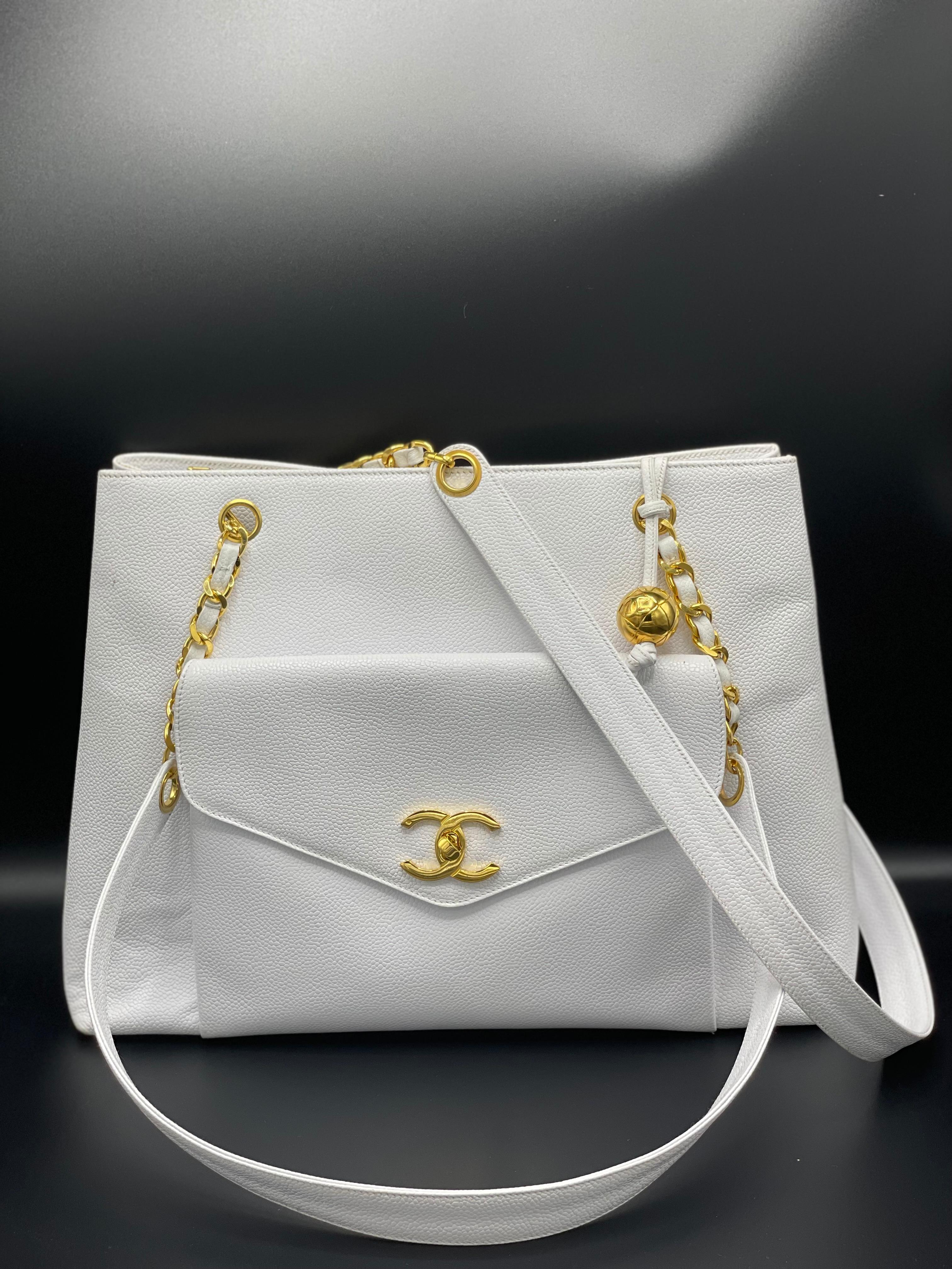 The inside is lined with leather and contains two pockets, each with a CC disk logo zip tag, two open compartments on each side, and a flat bottom for freestanding. Chanel Chain Tote bag with white caviar leather, large front exterior pocket with a