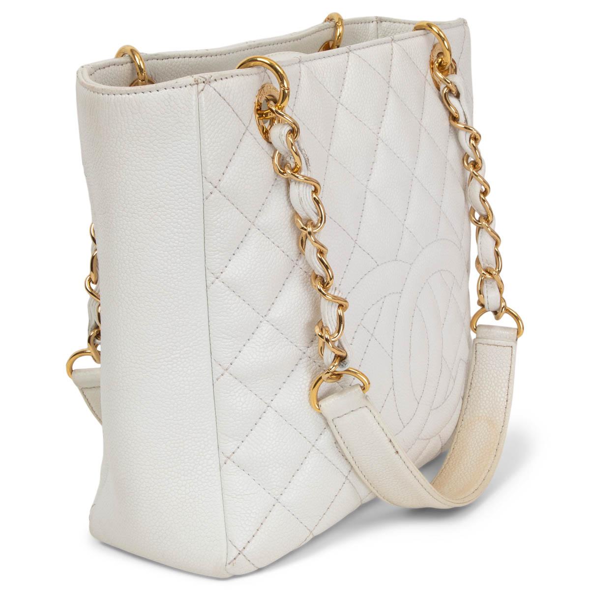 100% authentic Chanel Caviar Quilted Petite Shoppig Tote in white caviar leather featuring gold-tone hardware and CC stitching at front. Opens with a magnetic button on top and is lined in grey nylon with one zipper pocket againt the back and one