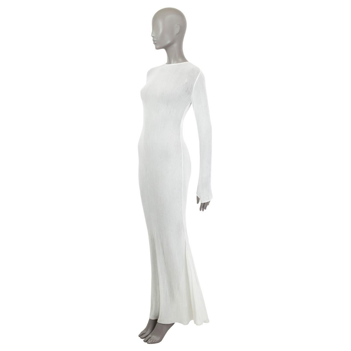 100% authentic Chanel semi sheer maxi dress in off-white cotton (100%). Features long sleeves and thumb holes at the cuffs. Opens with a hook and a concealed zipper at the back. Unlined. Shows some faint stains of wearing at the hemline, otherwise