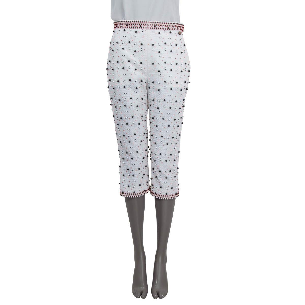 100% authentic Chanel 2019 La Pausa capri pants in white cotton (86%) and polyester (14%). Feature pearls all over the pants, two side slit pockets and zipped cuffs. Open with a concealed zipper, two hooks and a push button on the side. Lined in