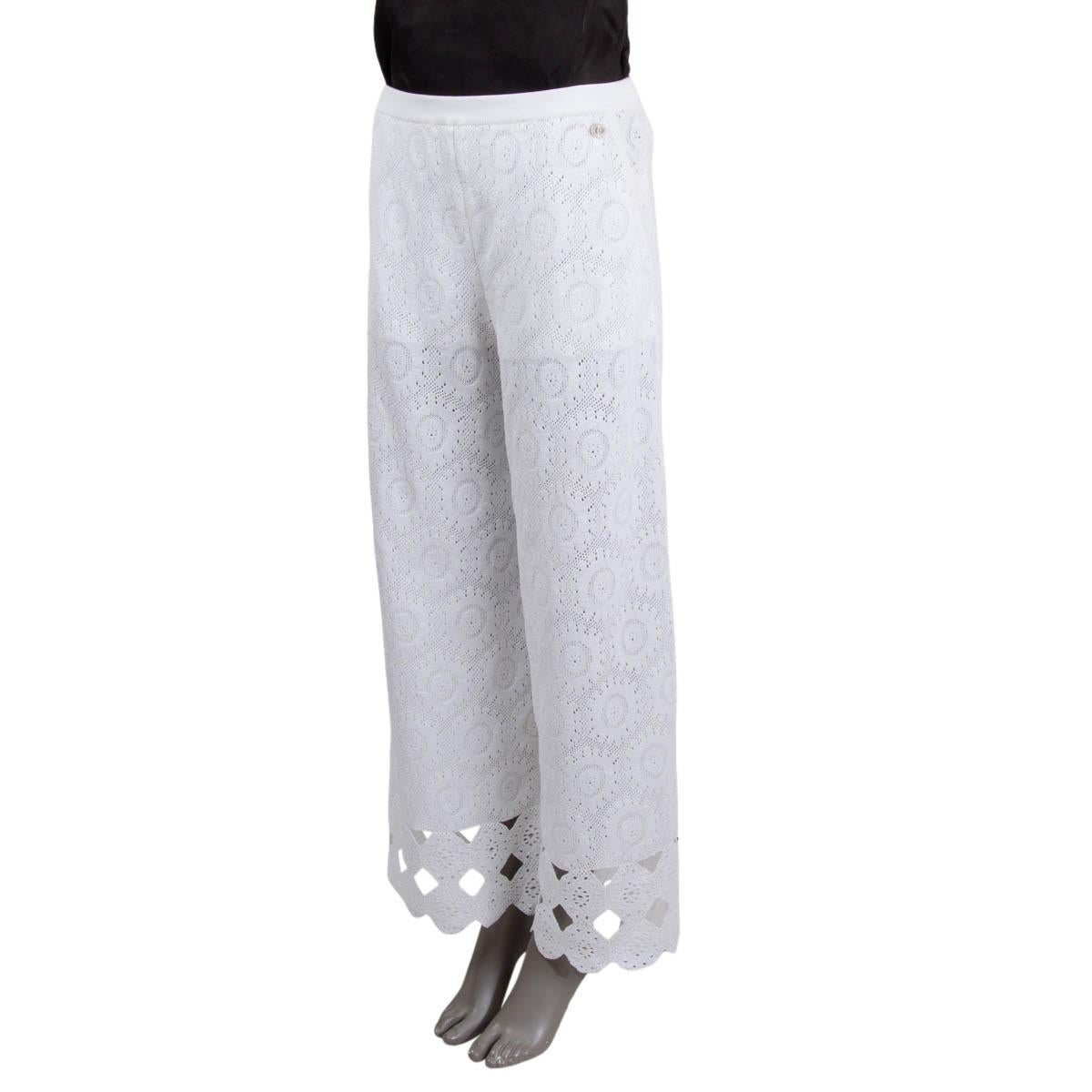 100% authentic Chanel 2020 high waist wide leg knitted crochet pants in white cotton (99%) and polyamide (1%) with a scalloped bottom hem. The top parts is lined and the legs are sheer. The design features two side slit pockets and an elastic