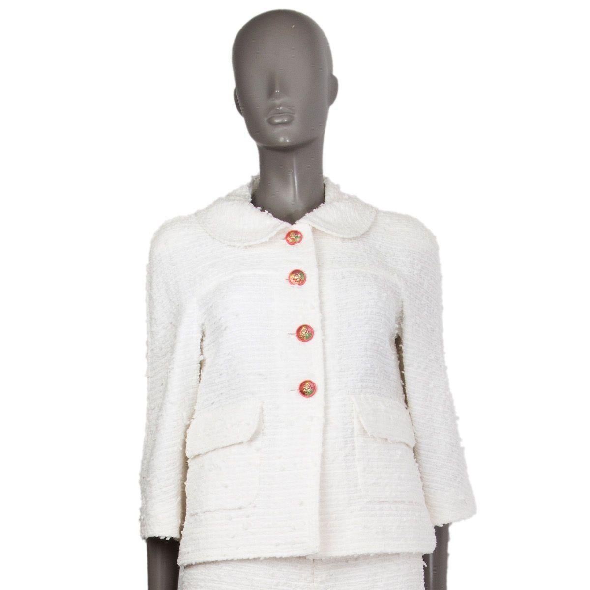 Chanel boucle blazer in white nylon (58%), cotton (31%), and wool (11%). With peter-pan collar, rounded slits on the sleeves and side seams, 3/4 sleeves, and two flap pockets on the front. Closes with lion-crest button on the front in pink, gold,