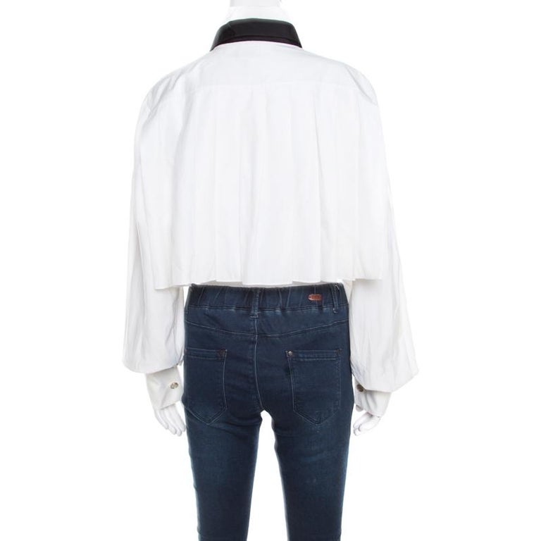 A cropped blouse like this from Chanel is just what you need in your wardrobe. White is the new black! This stylish piece is made from 100% cotton and is styled with contrasting tie detail to the front. Pair it with tailored pants and pumps for a