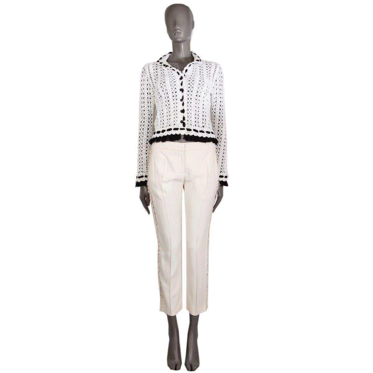 Chanel crochet jacket in off-white nylon (81%), cotton (18%), and spandex (1%) with looped trim and hemline in black silk organza (100%). Closes with small CC buttons in black plastic. Unlined. Has been worn and is in excellent condition. 

Tag Size