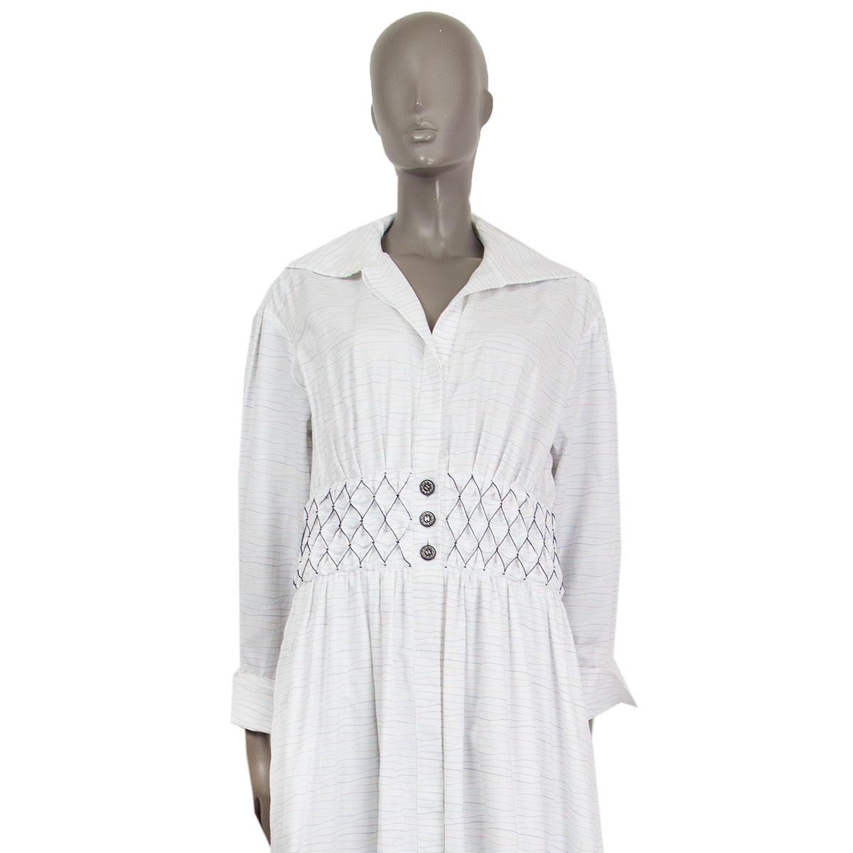 100% auténtico Vestido camisero largo Chanel colección crucero 2019 de algodón blanco (100%) con rayas multicolores y adorno de nido de abeja en la cintura. Se cierra con siete botones ocultos y con tres botones con el logotipo en relieve en la