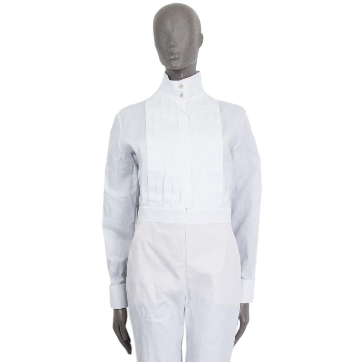 100% authentic Chanel fitted jumpsuit in white cotton (100%) with a front pleat, a band-collar, two side-pockets, knee-length shorts lined in a tan colored underwear. Closes in the front with a button fastening and a concealed zipper. Brand