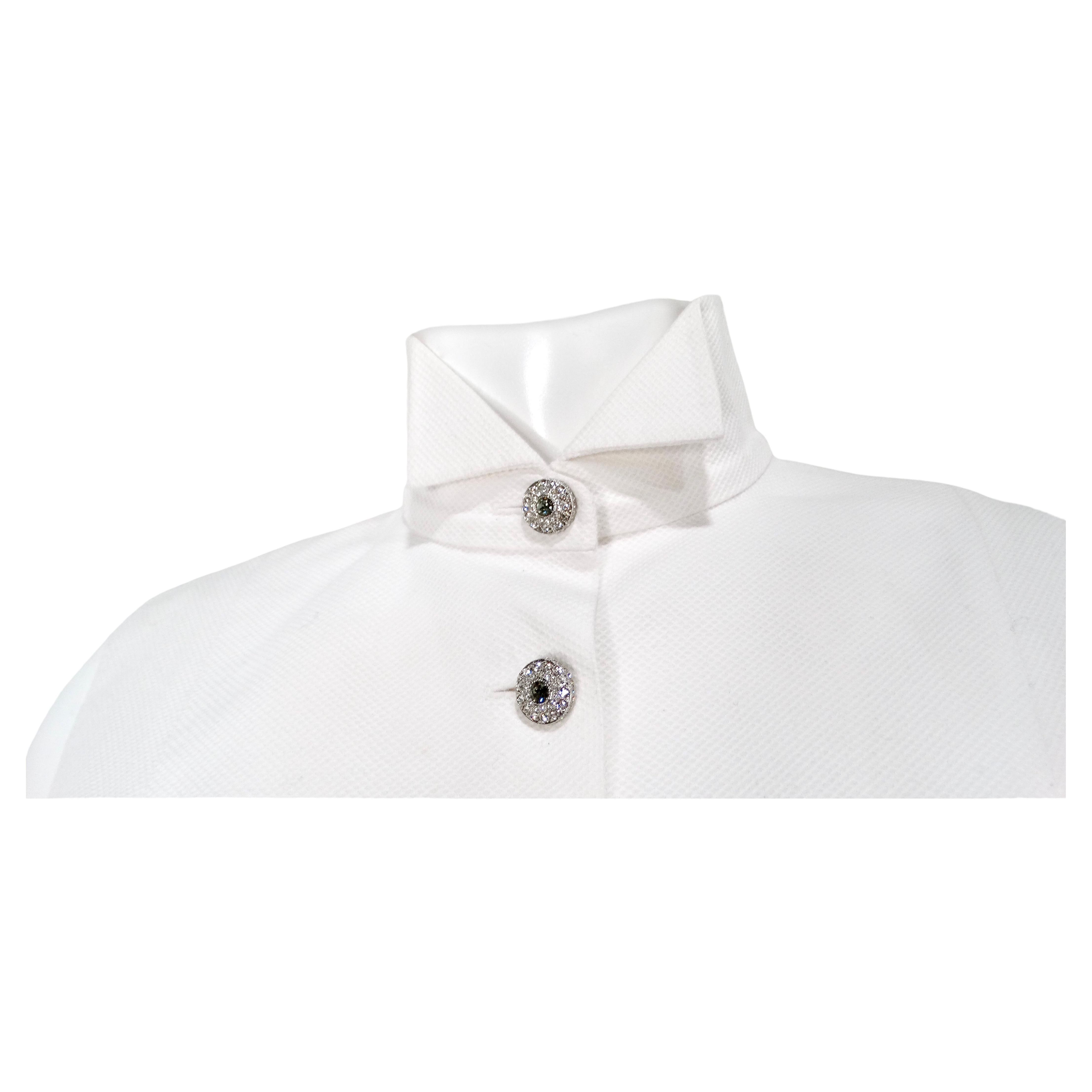 Il gilet Chanel White Cotton Crystal Button-Up Collared è un capo sofisticato e versatile che incarna un'eleganza senza tempo con un tocco moderno. Realizzato in cotone bianco di alta qualità, questo gilet offre una silhouette nitida e pulita,