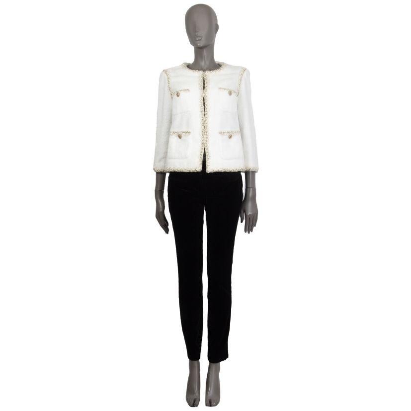 Chanel terry-cloth collarless blazer in off-white cotton (98%) and polyester (2%). With crochet lurex trims, four buttoned patch pockets on the front, buttoned sleeves, and signature chain around the inside of the hemline. Closes with concealed