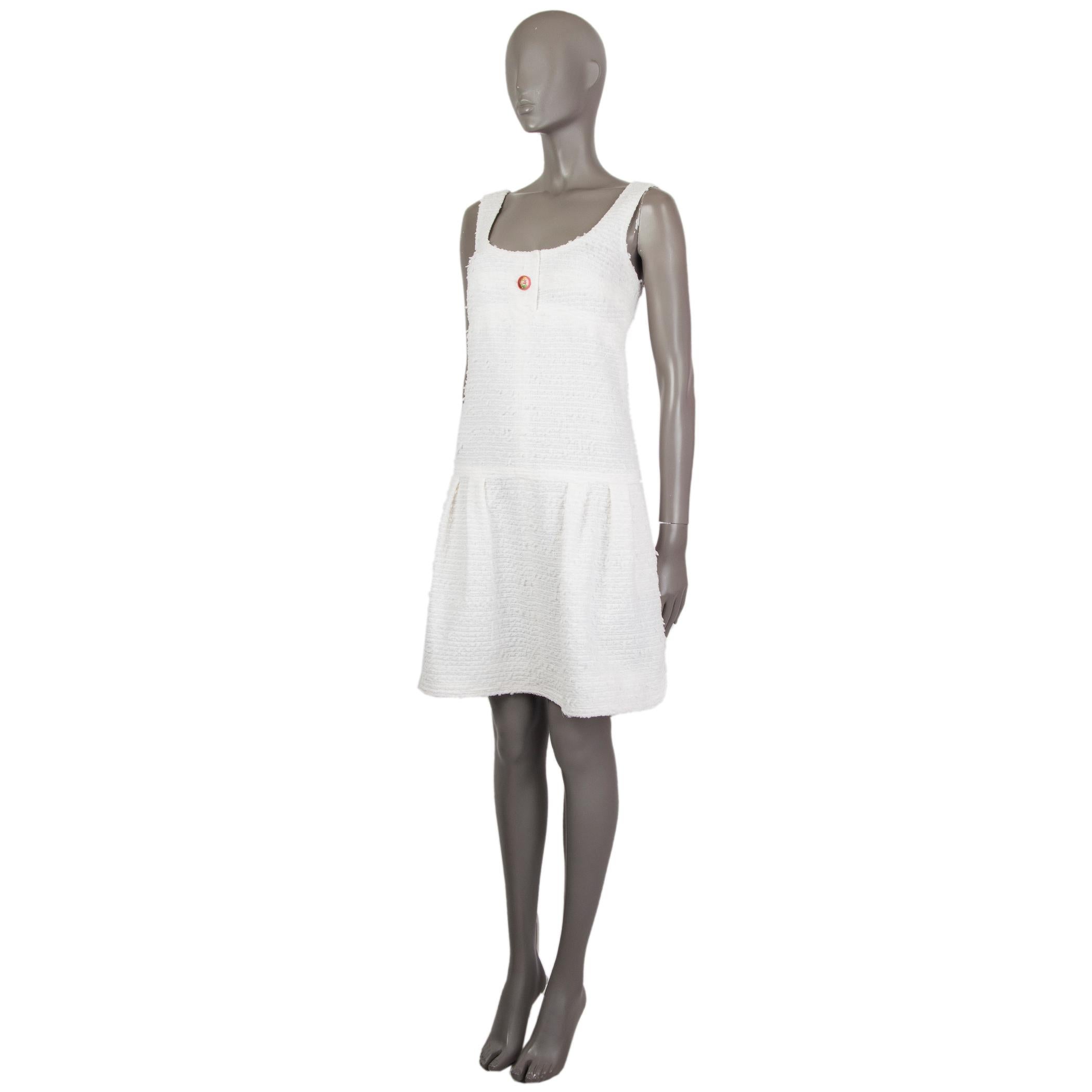 Chanel tweed pinafore dress in off-white polyamide (58%), cotton (31%) and wool (11%) with a round neck. Has side pockets. Closes on the front with a pink button and on the back with a concealed zipper. Lined in cotton (75%) and silk (25%). Has been