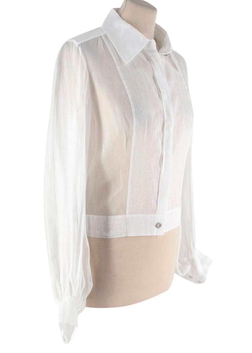 Chanel Camicetta a maniche lunghe in voile di cotone bianco semi trasparente
 

 - Camicetta bianca semitrasparente realizzata in voile di cotone pregiato
 - Chiusura frontale con bottoni nascosti
 - Bottoni in tonalità argento con dettaglio inciso