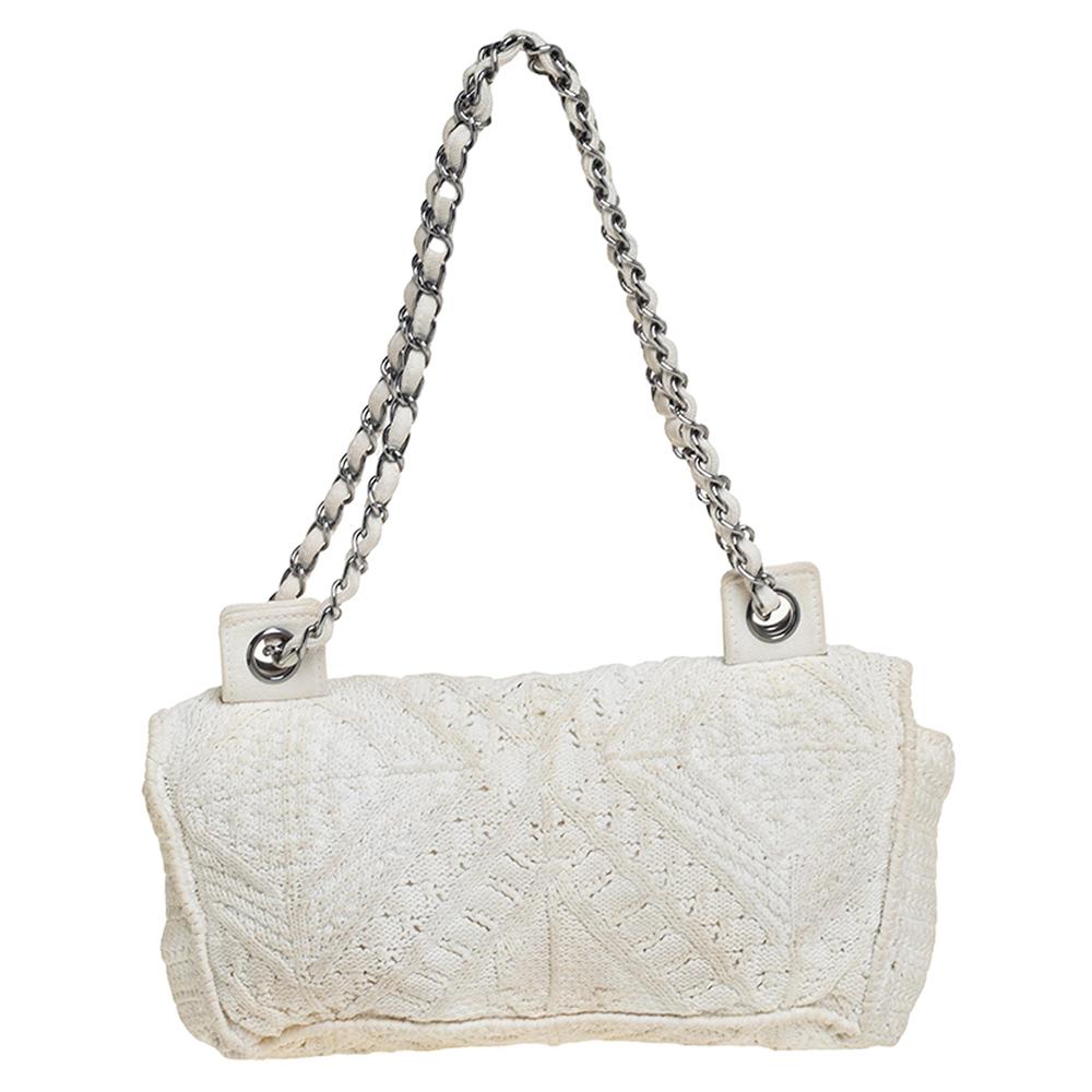 We are in utter awe of this flap bag from Chanel as it is appealing in a surreal way. Exquisitely crafted from crochet fabric in a white hue, it bears the signature label on the canvas interior and the iconic CC turn-lock on the flap. The piece has