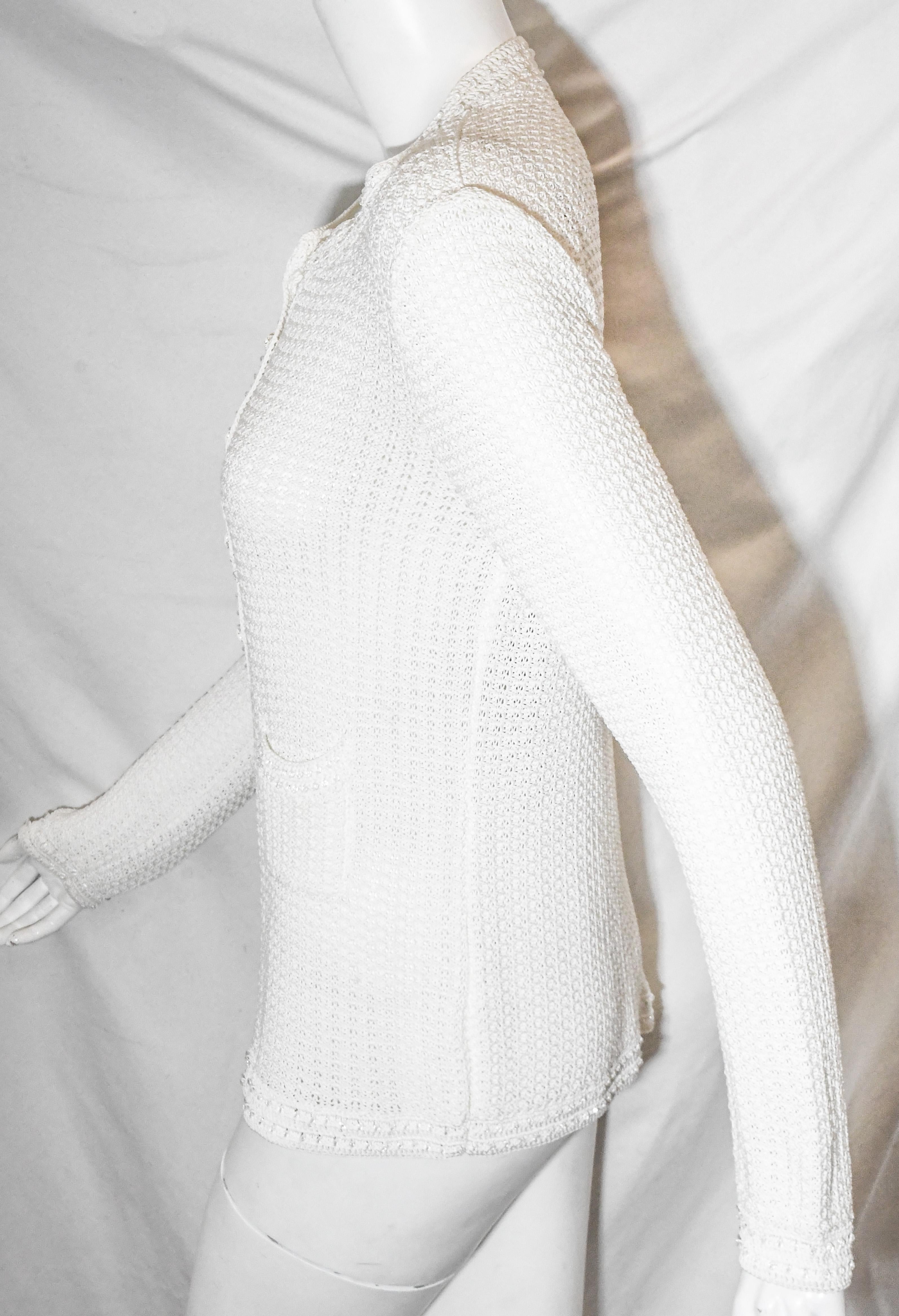 Chanel white crochet sweater contains a round collar and two front patch pockets.  This Chanel cardigan features long sleeves,  knit to perfection.  For closure, white CC buttons.  Chanel sweater in excellent condition.  
Made in France