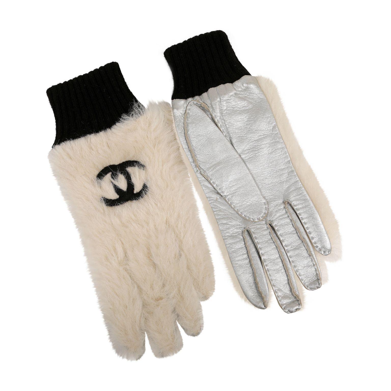 Diese authentischen Chanel White Fur CC Handschuhe sind tadellos.  Weiße Winterhandschuhe mit schwarzer, ineinandergreifender CC-Stickerei und schwarzen Strickbündchen.  Silbernes Metallic-Leder auf der Handfläche.   Inklusive Tasche oder Box. 