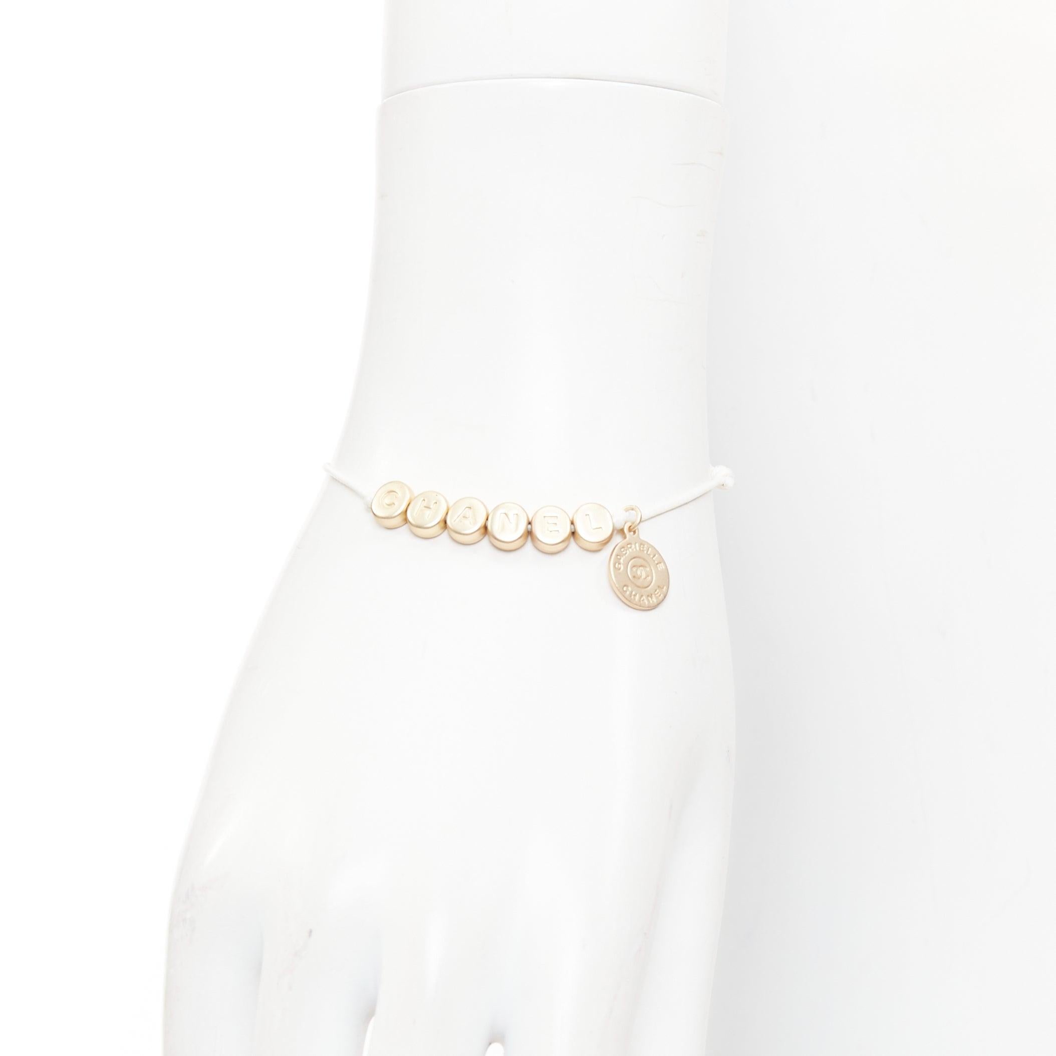 CHANEL brazalete de la suerte con logotipo en tono dorado blanco abalorio de letra de hilo blanco
Referencia: TGAS/F00017
Marca: Chanel
Material: Metal, Tejido
Color: blanco, dorado
Patrón: Sólido
Cierre: Ajustable

CONDICIÓN:
Estado: Excelente,