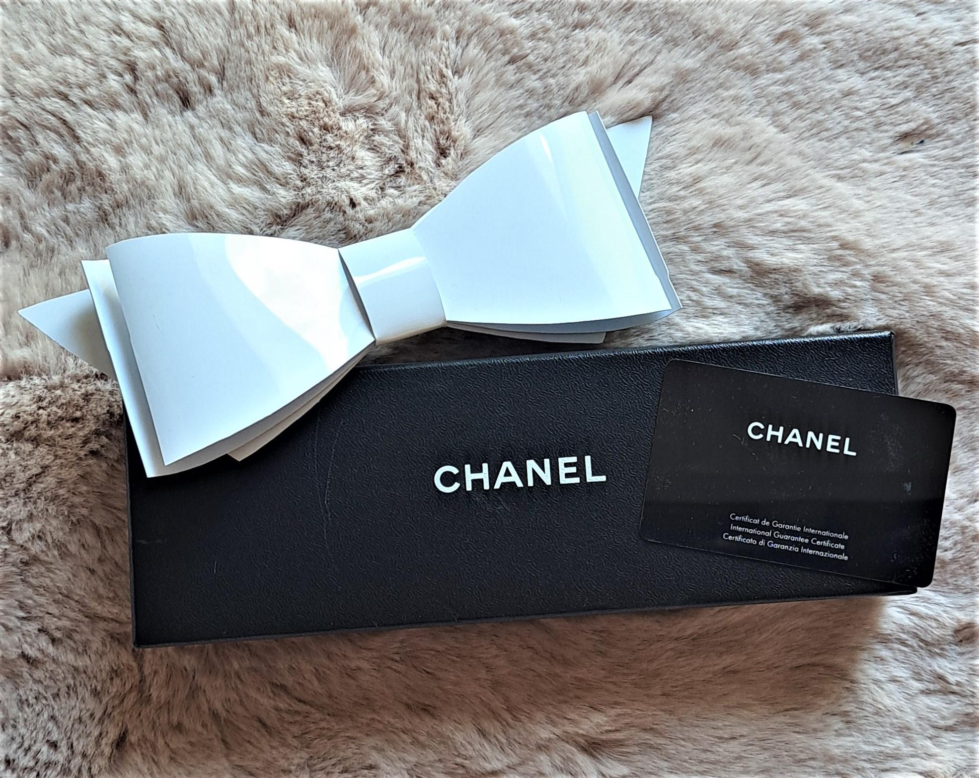Este rarísimo artículo de coleccionista vintage, un moño de Chanel hecho a mano, probablemente fue regalado a VIPS en  una Pasarela Chanel a principios de los 90. Los regalos VIP suelen darse de forma selectiva. Está muy bien conservada y perteneció