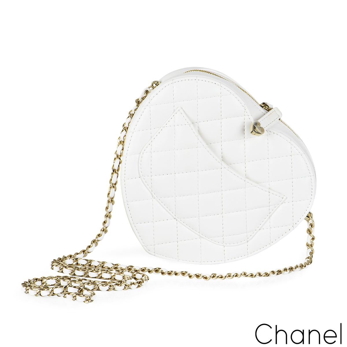 A coveted white Chanel Heart Bag. The exterior of this Heart Bag is crafted with white lambskin leather in the signature diamond style stitching with gold-tone hardware and has a signature logo zipper pull. It features a front flap with signature CC