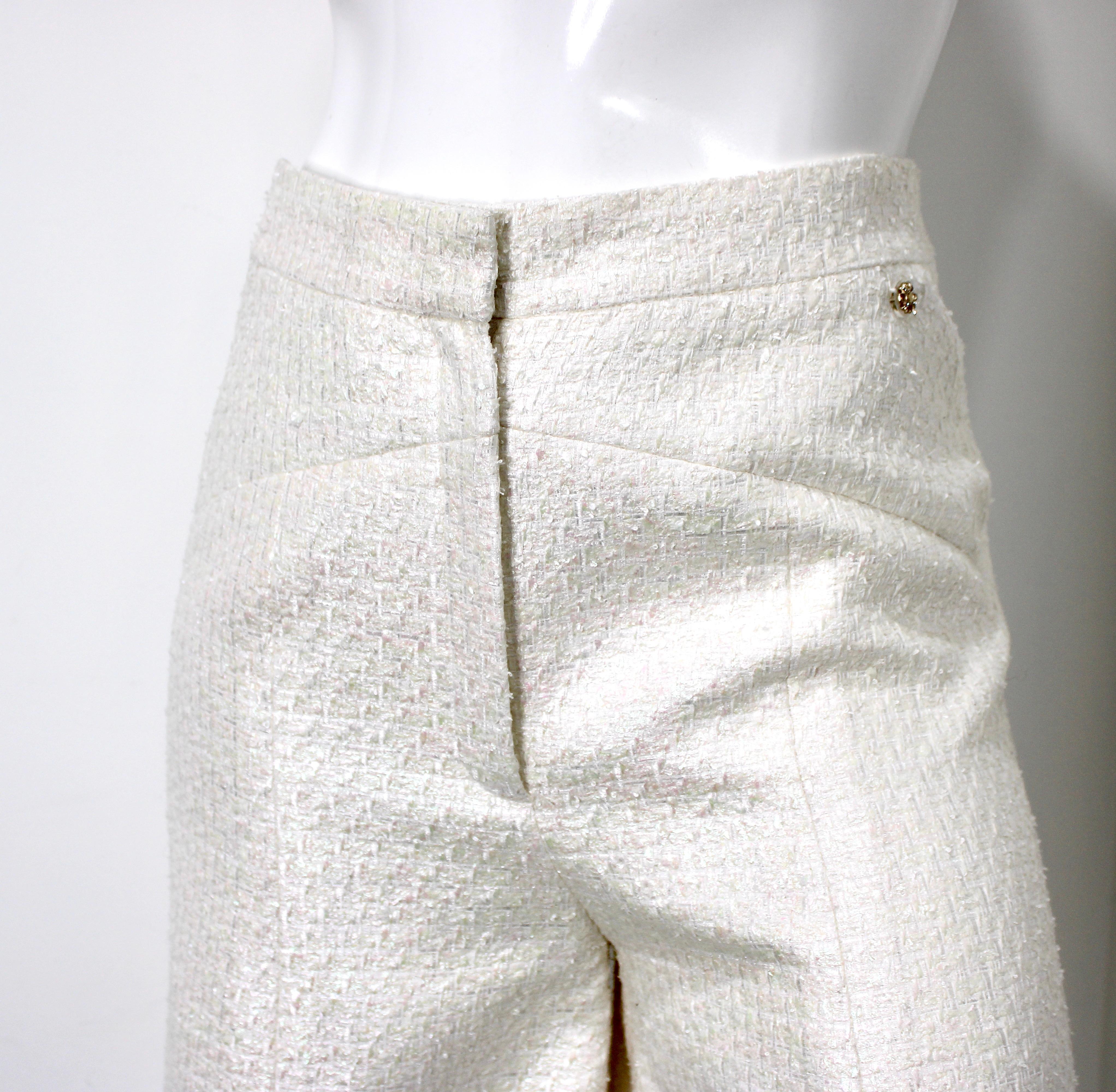 Le pantalon large en tweed irisé blanc de Chanel est une pièce luxueuse qui s'ajoute à toutes les garde-robes. Fabrice en tweed avec une finition irisée, ce pantalon exsude l'élégance et la sophistication moderne. La silhouette à jambes larges offre
