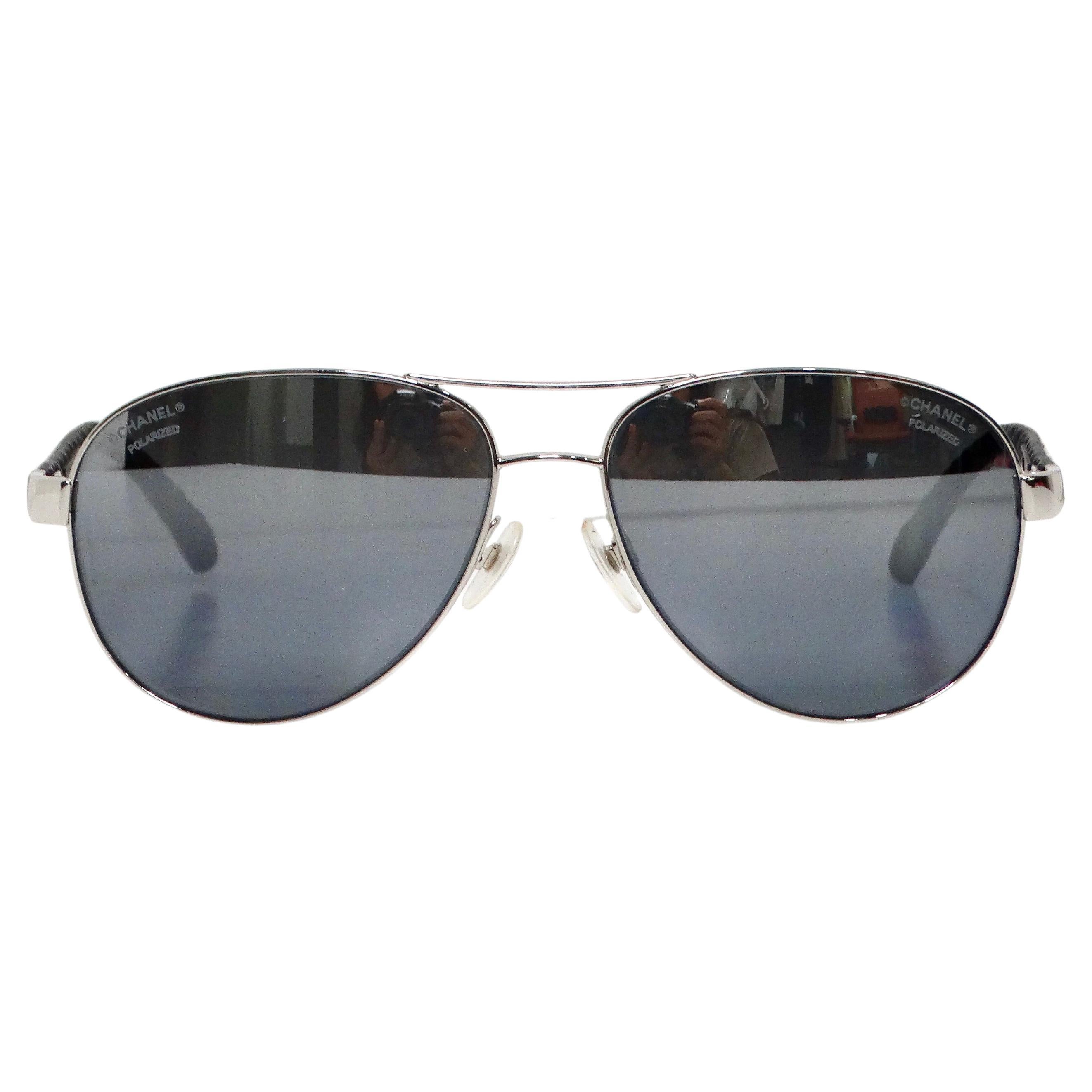 The Chanel White Lambskin Quilted Aviator Sunglasses with Polarized Lenses are a sophisticated blend of luxury and functionality. Crafted with a sleek metal frame, these sunglasses feature iconic white lambskin quilted leather arms that add a touch