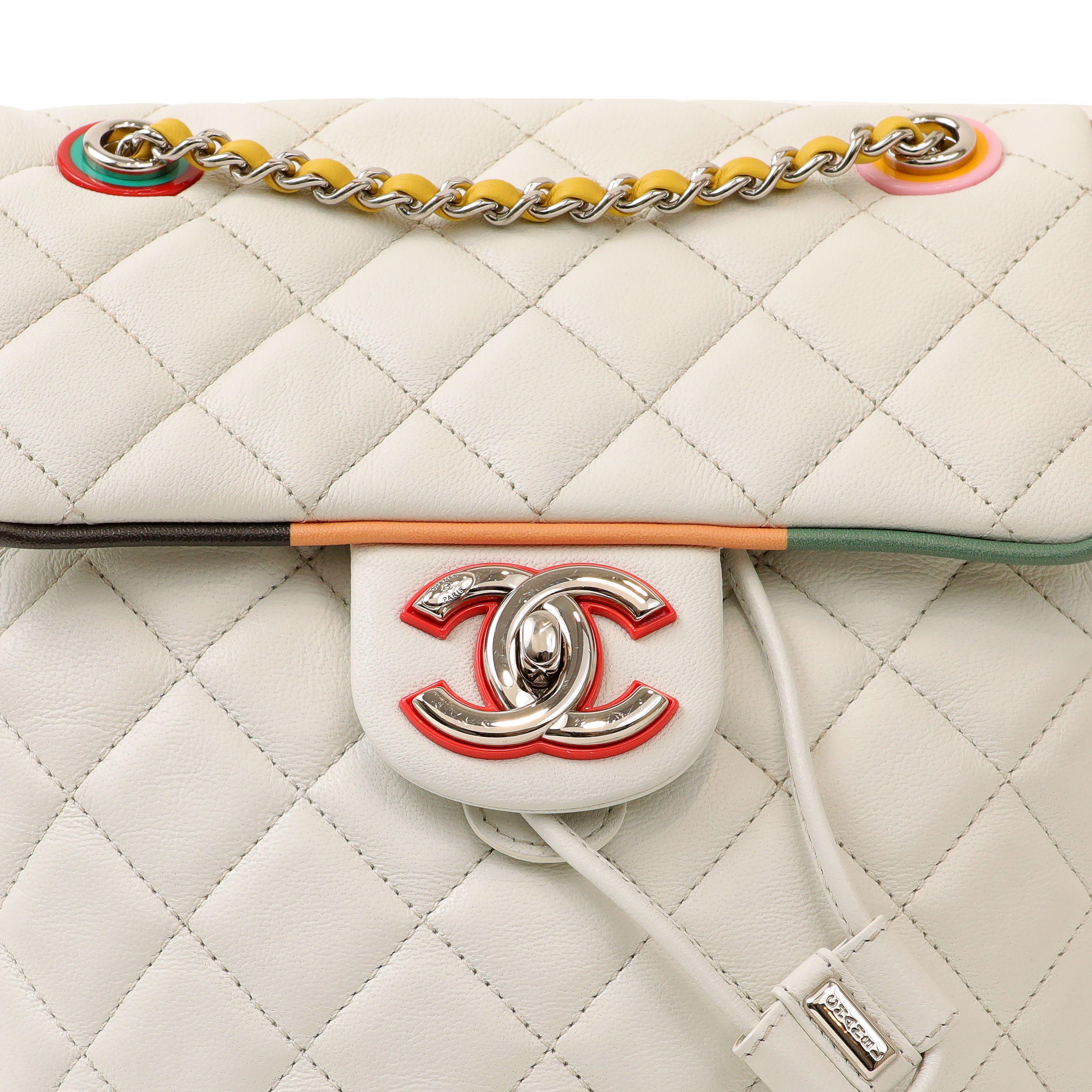 This authentic Chanel White Lambskin Urban Spirit Back is pristine.  Snowy white quilted lambskin with colorful trimmings and color blocked rear panel. Flap closure with silver hardware.  Adjustable shoulder straps.    Dust bag included. 

PBF 13913
