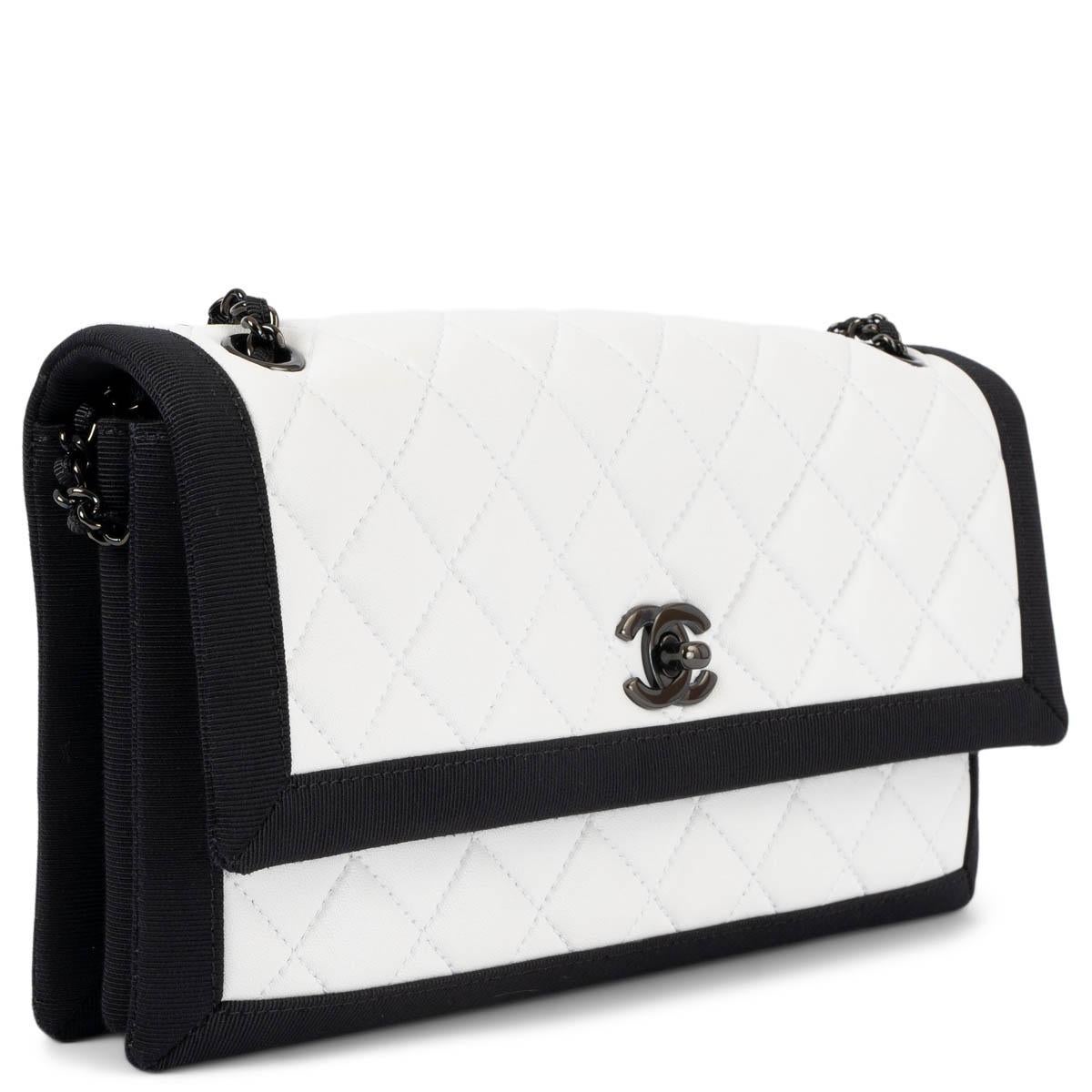 100% authentic Chanel flap bag in smooth white quilted Nappa leather and black grosgrain trim. The design features a slit pocket on the back, shiny gunmetal CC turn-lock and chain. The interior is divided in three compartments and has a zipper