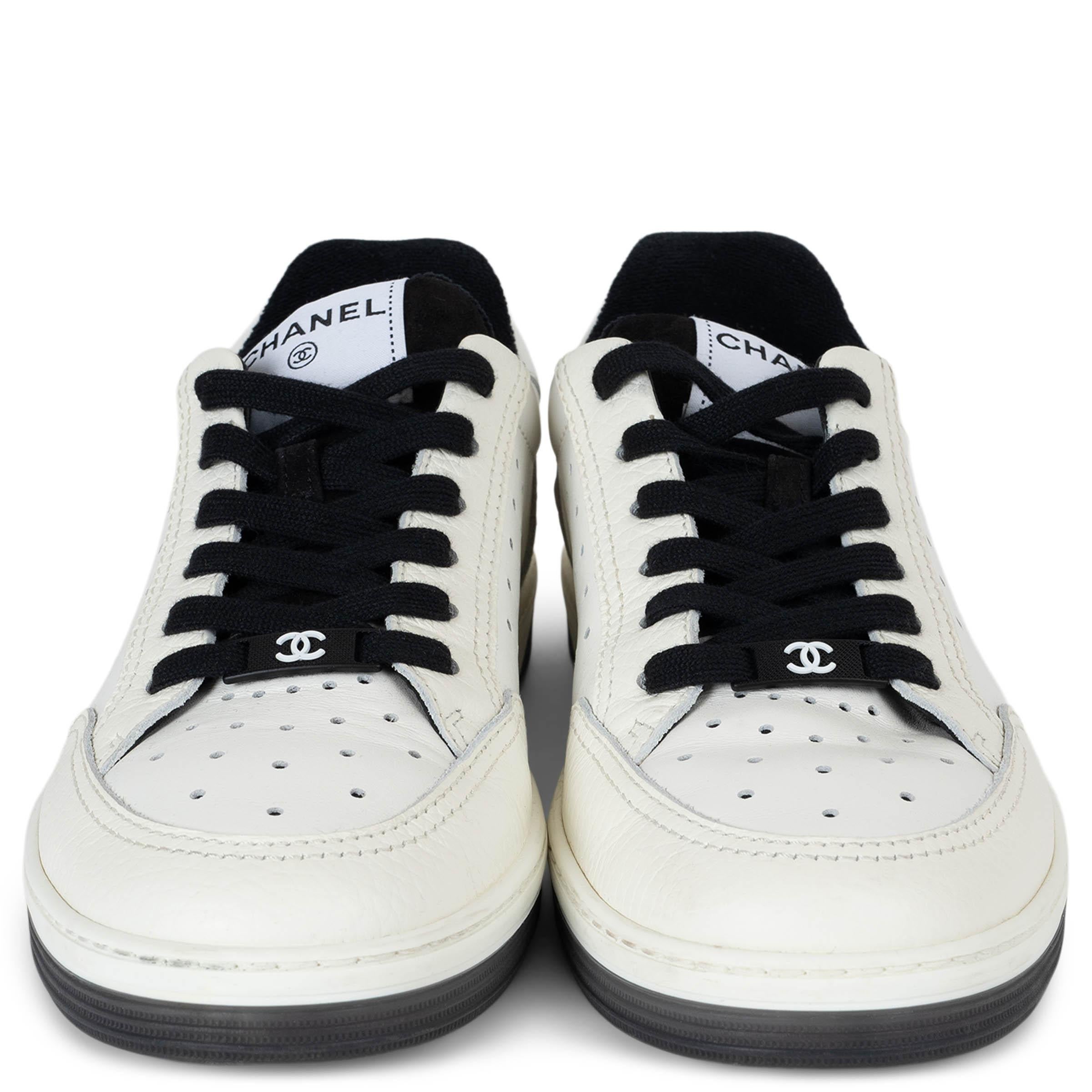 Diese 100% authentischen Chanel Low-Top-Sneaker sind aus weißem, perforiertem Leder gefertigt und unterstreichen die schlichte, minimalistische Ästhetik der Maison. Das genarbte Leder und die Logoprägung an der Ferse verleihen dem Schuh einen
