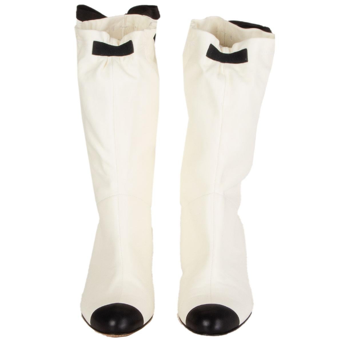authentic Chanel mid-calf boots in off-white soft lambskin with a black toe and heel. Bow detail around calf. Bradn new. Comes with dust bag. 

Imprinted Size 37.5
Shoe Size 37.5
Inside Sole 24.5cm (9.6in)
Width 7.5cm (2.9in)
Heel 6cm (2.3in)
Shaft