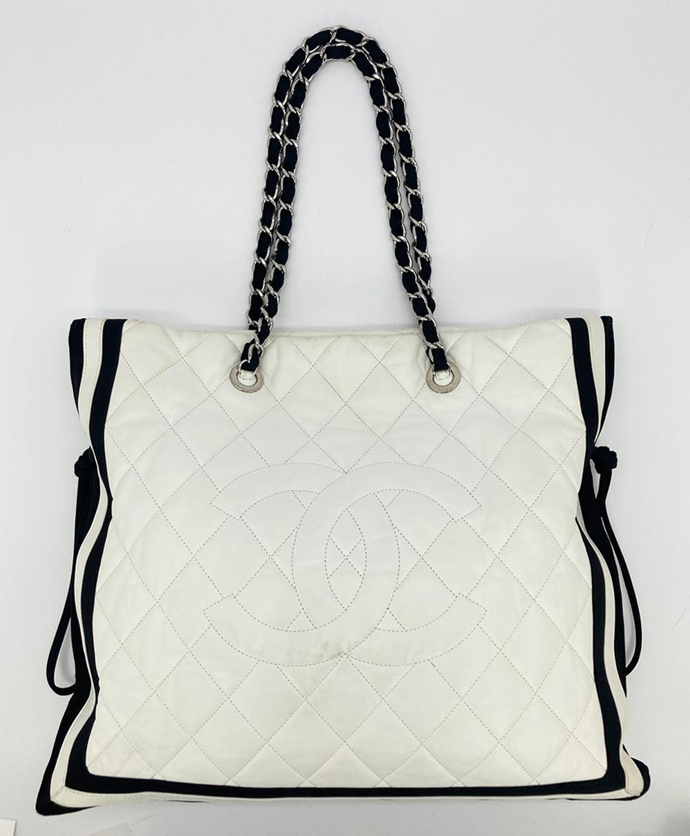 Chanel White Leather Black Grosgrain Quilted CC Shoulder Bag Tote in excellent condition. White quilted lambskin trimmed with black grosgrain trim and silver hardware. Woven ribbon and silver chain shoulder straps. Exetrior side drawstring feature