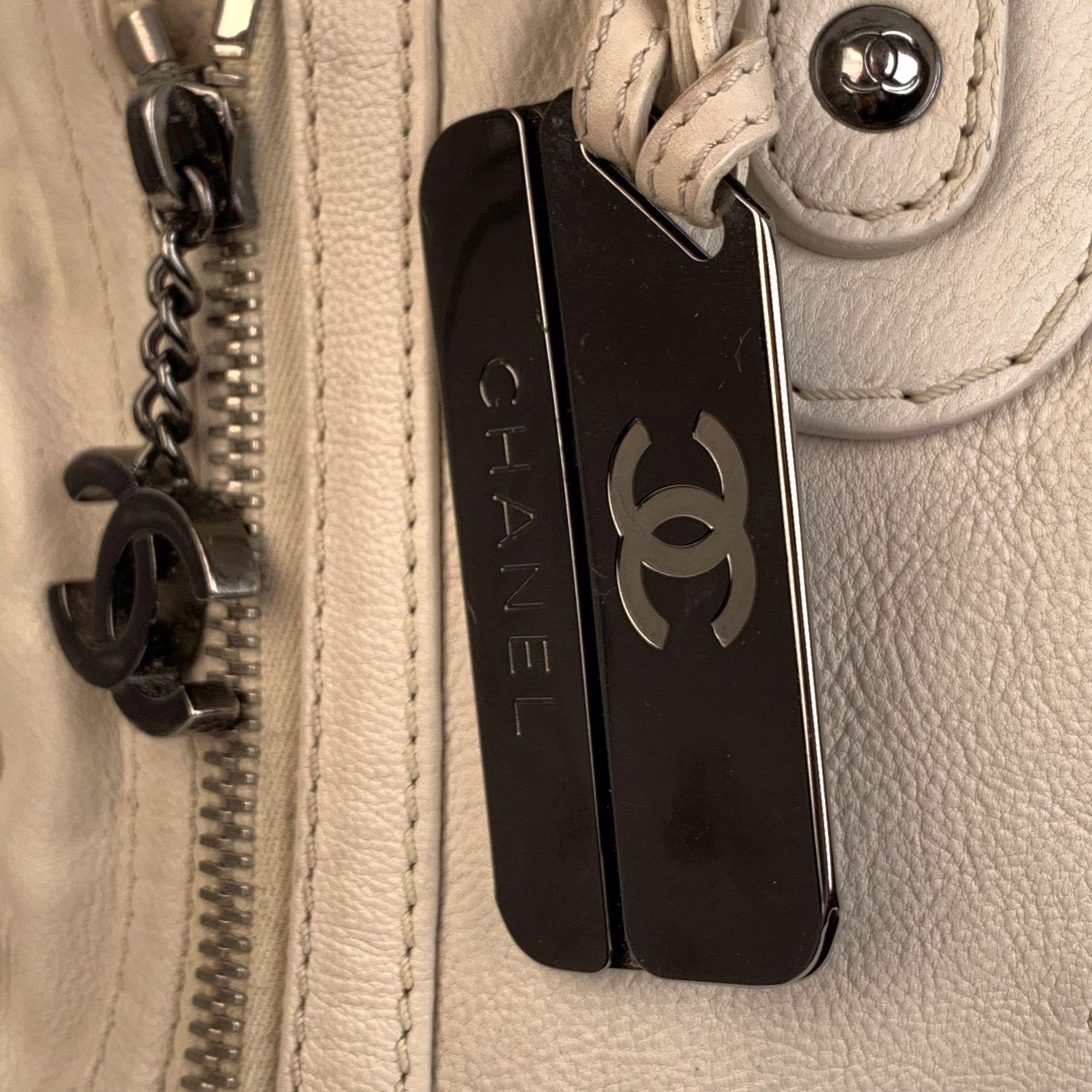 This bag will come with a Certificate of Authenticity provided by Entrupy, at no further cost.

Beautiful white leather bowling bag by CHANEL with CC Chanel logo on the front. Silver metal hardware. Side pockets with quilting. 1 front section with