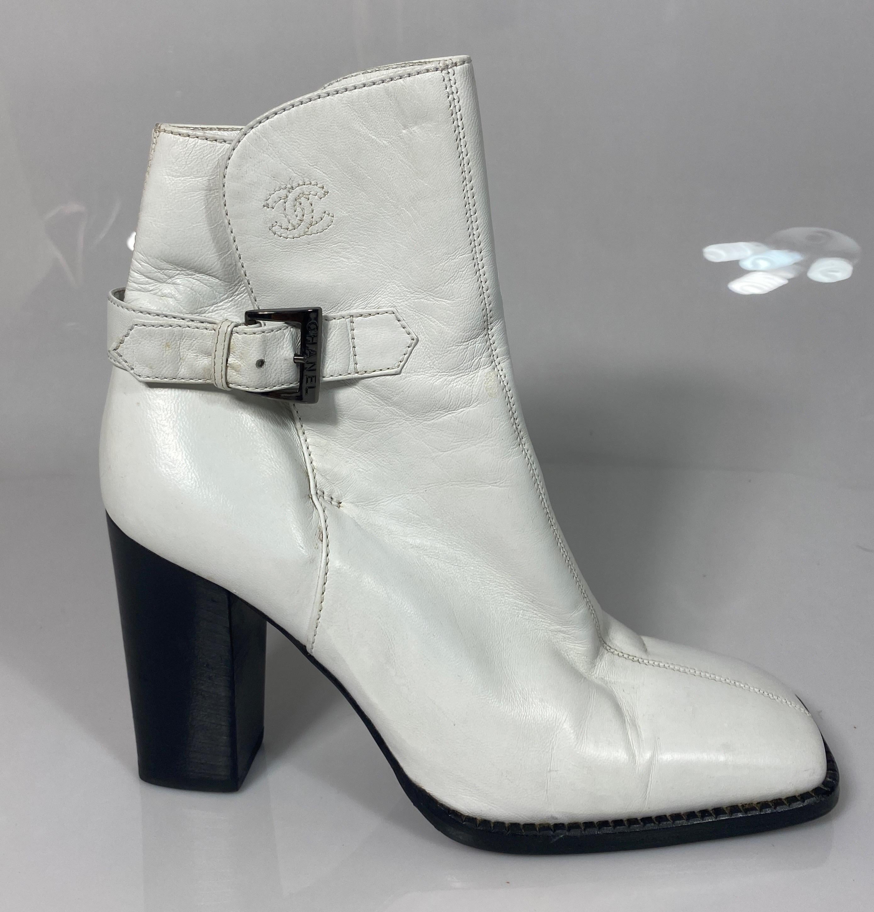Chanel White Leather Chunky Wood Stack Heel Short Boot -Size 36.5. This rare Chanel White Bootie is as described below:
Square toe box
3.75” Heel Height
1.25” X 1.5” Wood stack heel
1” wide leather strap with Chanel buckle around ankle 
Leather