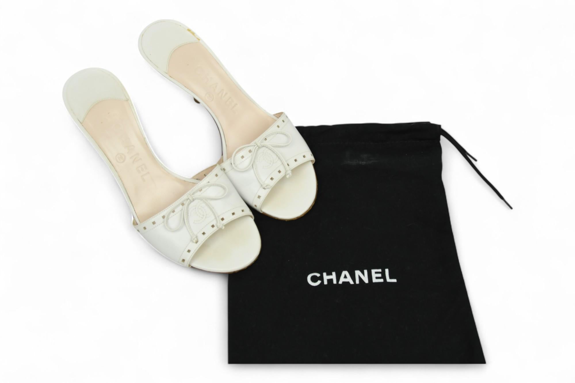 Chanel Pantolette aus weißem Leder mit Absatz und Schleife
Diese Chanel Pantoletten aus weißem Leder strahlen zeitlose Eleganz und raffinierte Raffinesse aus. Das aus geschmeidigem weißem Leder gefertigte Modell zeichnet sich durch eine schlanke,