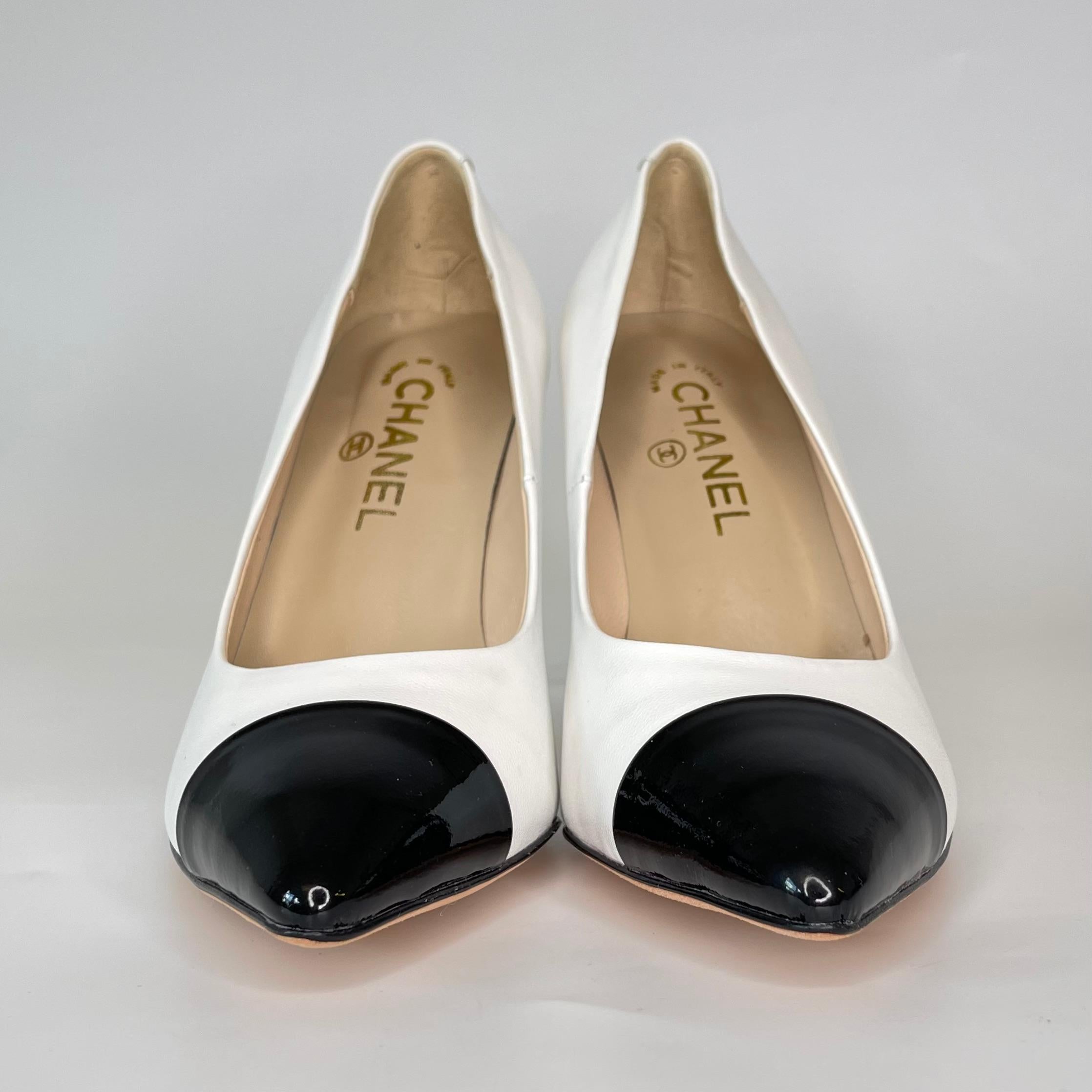 These Chanel pumps feature white and black leather with a faux-pearl fixed at the heel. CC logos The heel is finished with CC logos that on the heel. The shoes have a leather lined upper and sole for a comfortable fit.

COLOR: White
MATERIAL: