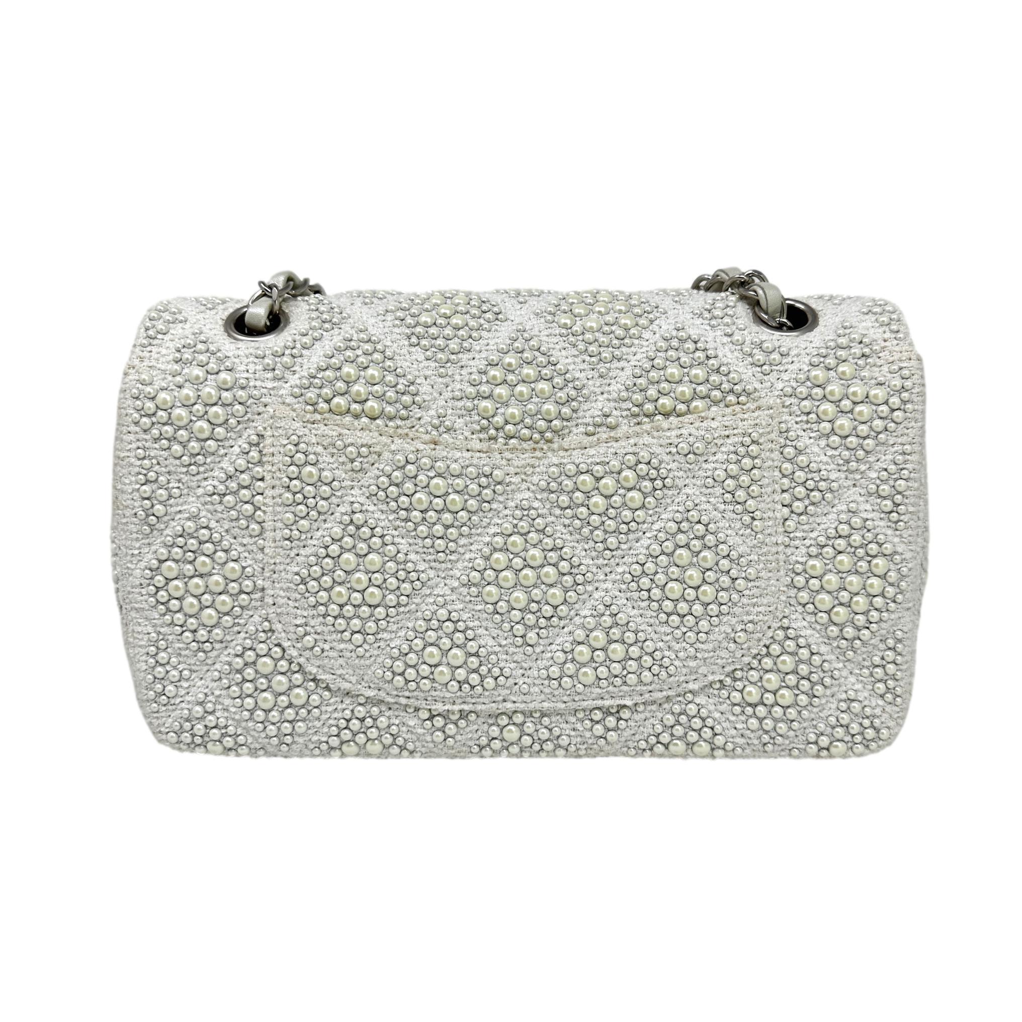 Description: This is a gorgeous Chanel White Medium Classic Flap Pearl Embellished Tweed Bag featuring brushed silver hardware, Interlocking CC lock closure, adjustable chain link strap with iridescent interwoven leather. The interior flap is a lush